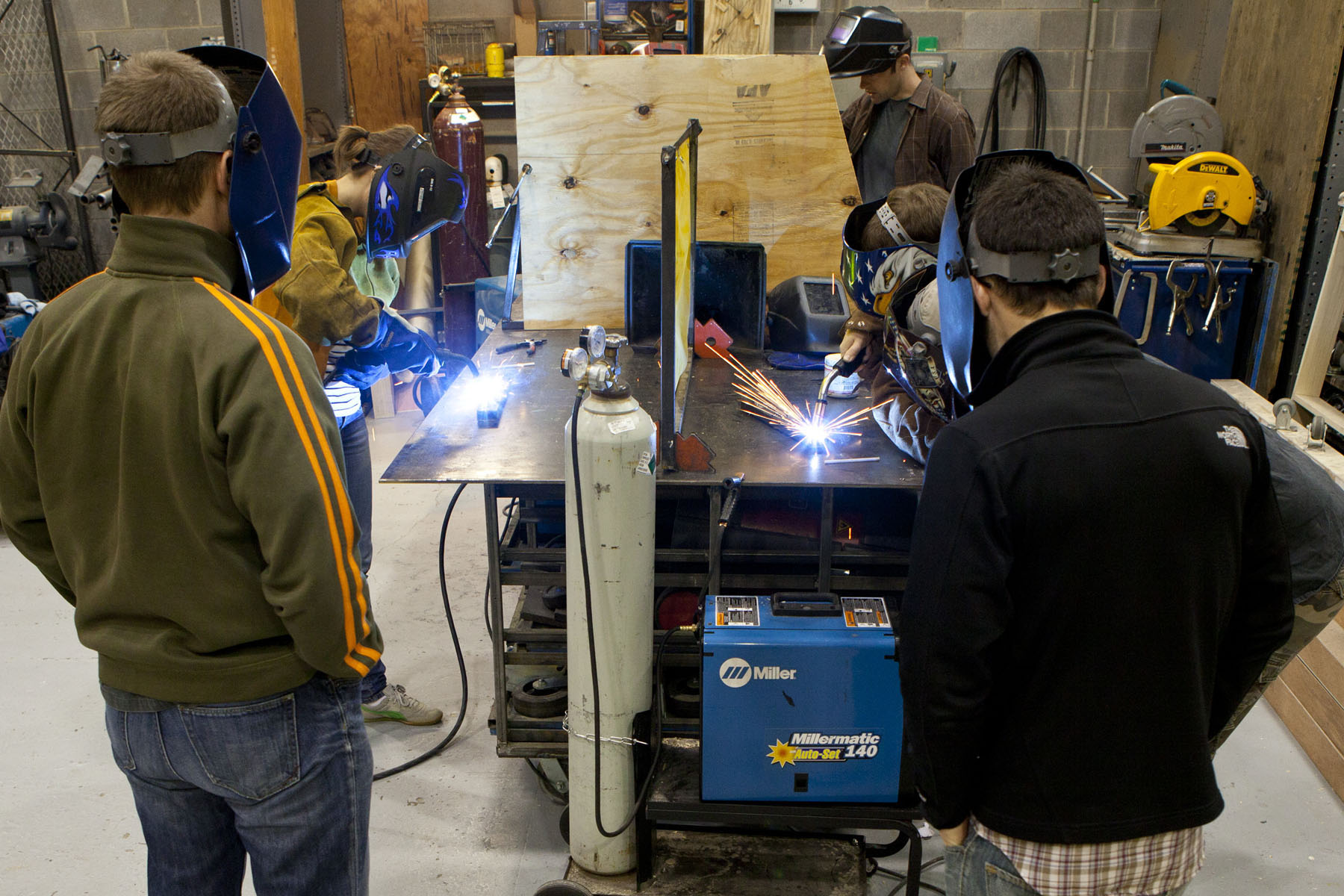 Students in a workshop practicing welding