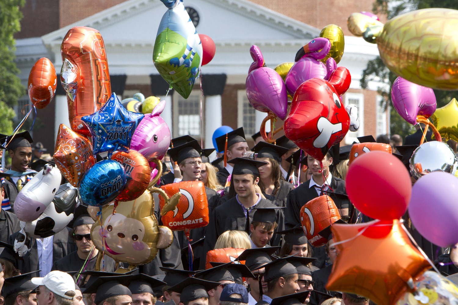 Graduates standing on the Lawn holding balloons