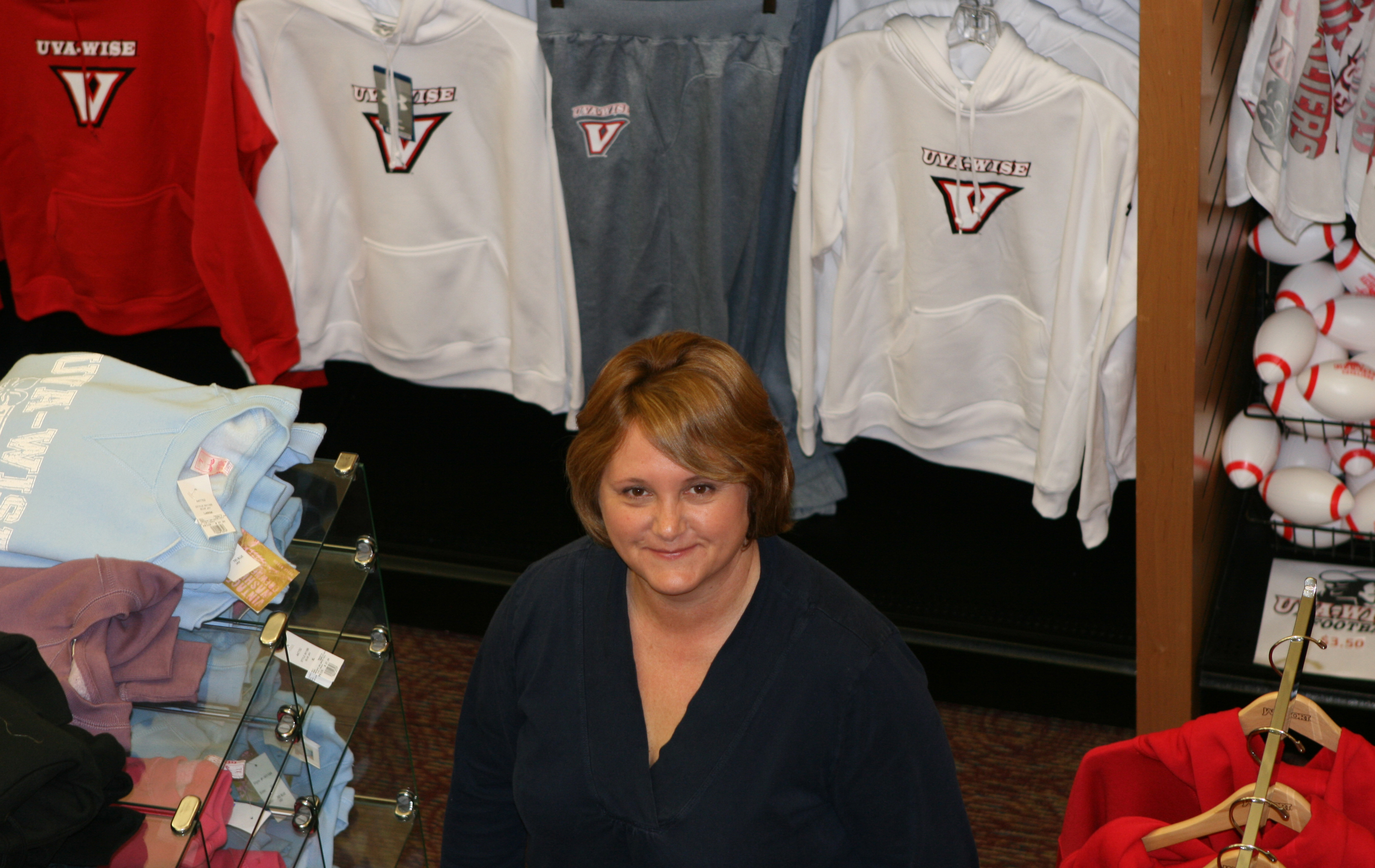 Sheila Hileman standing in a store with UVA wise clothing