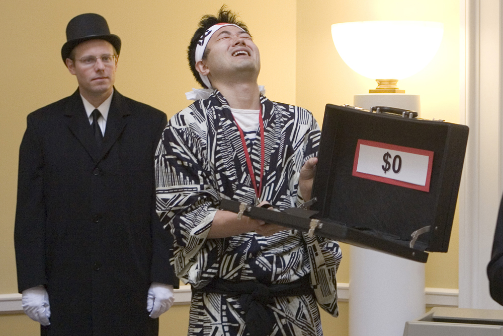 Hideki Inoue opens a brief case with a sign inside that says $0