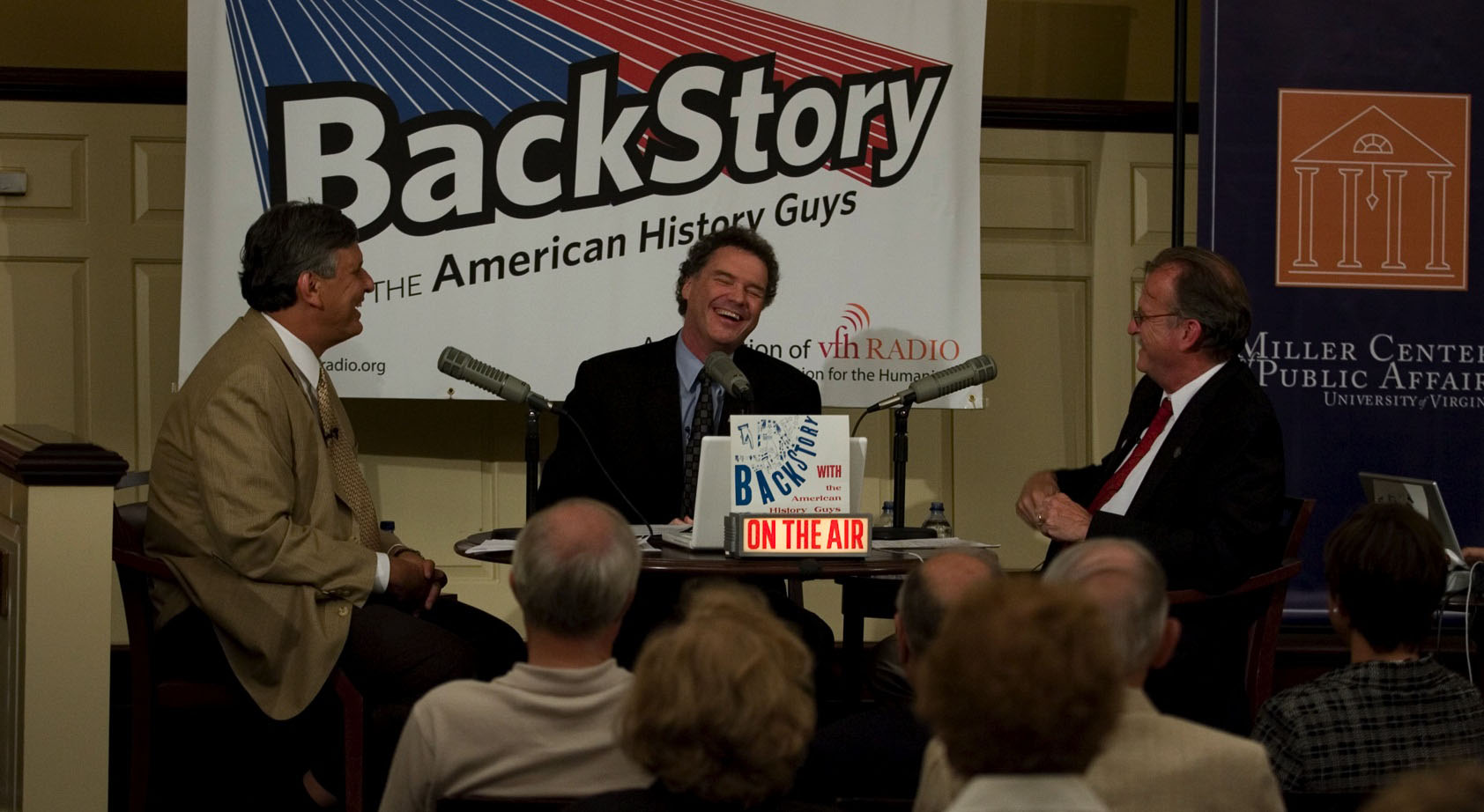 Brian Balogh, Ed Ayers and Peter Onuf sit at a table with microphones talking during a live radio broadcast
