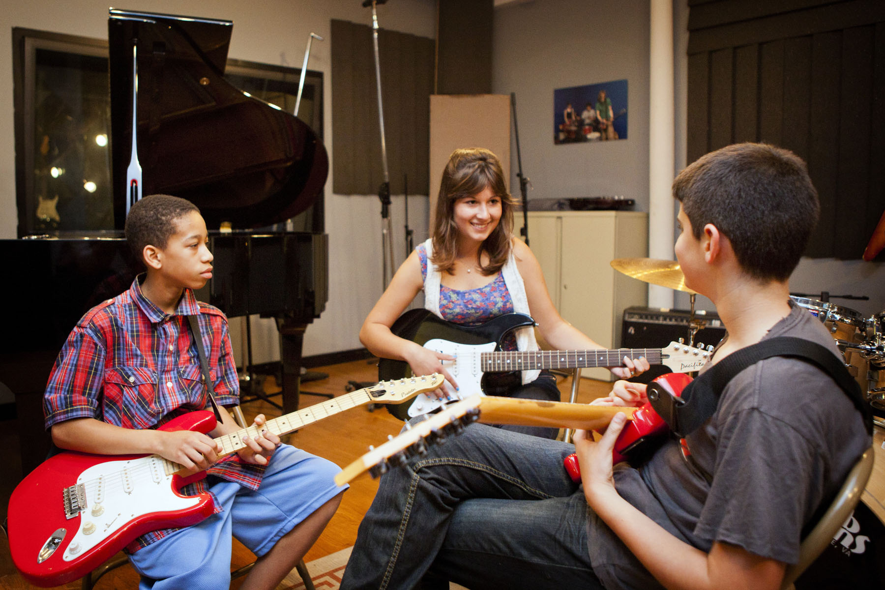 Three students play guitar.  Left to right: Tyberius Conn, Christie Boyden, and James Hill