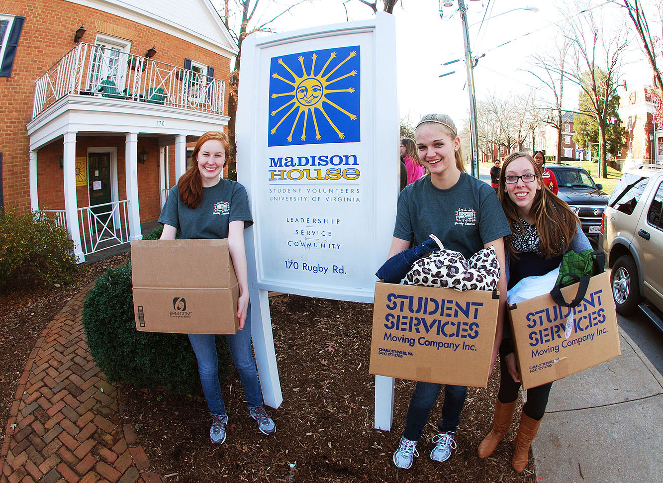 Student volunteers, from left, Ellen Schleckman, Stephanie Bolton and Jennifer Breeze carry boxes full of donations into Madison House