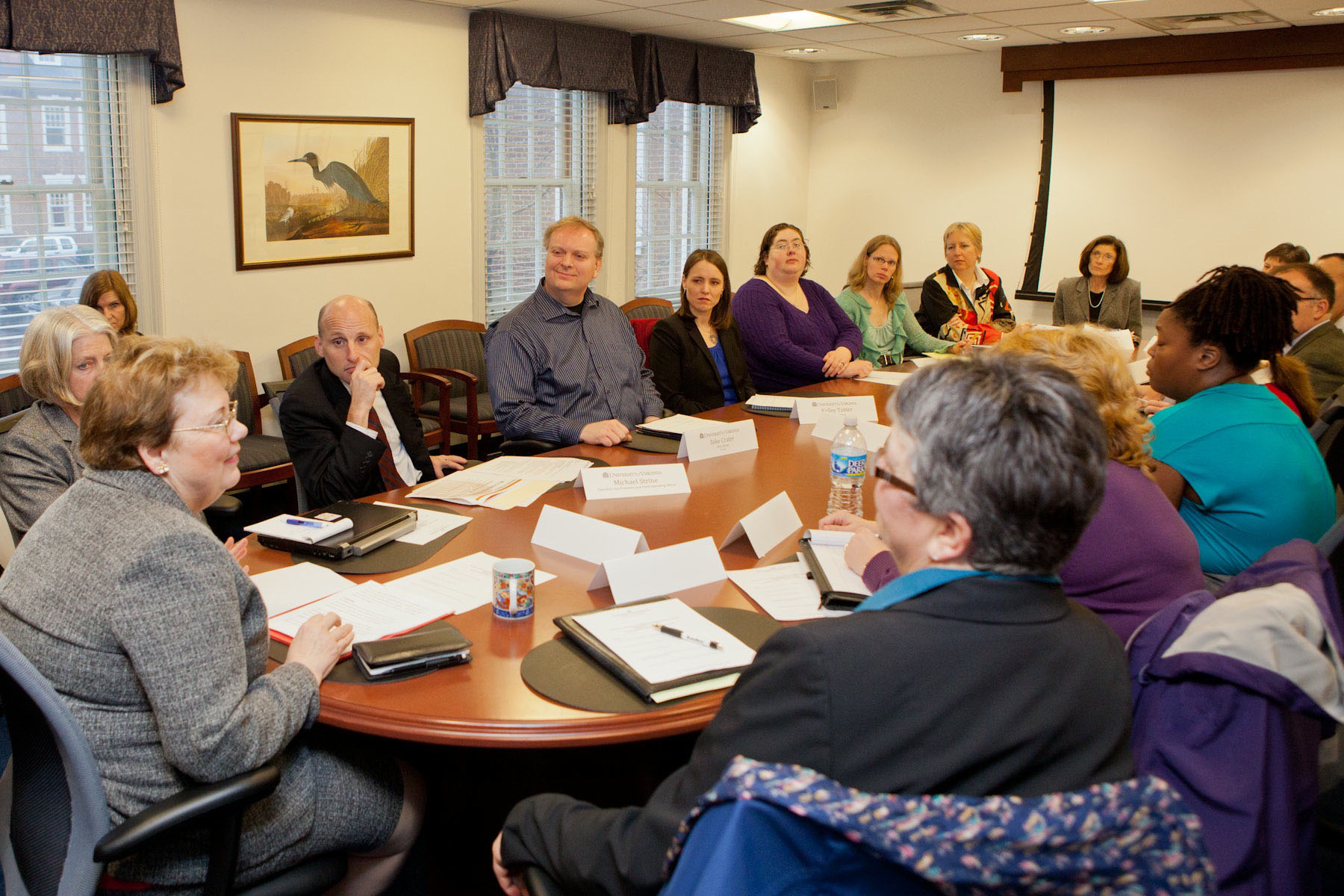 President Teressa Sullivan talks to employee council members at a wooden oval table