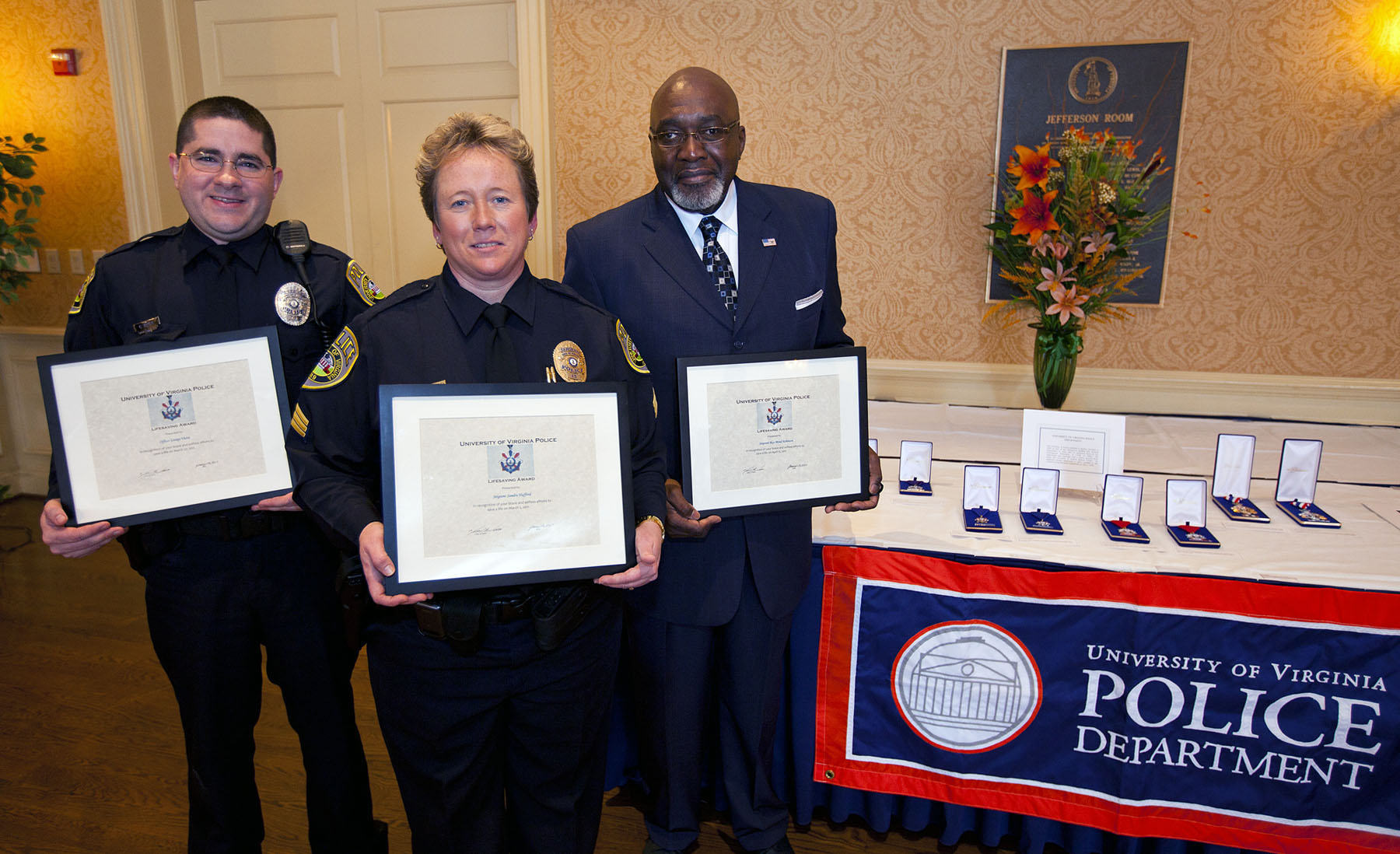 Police officers holding framed awards.  Left to right: Police Officer George Viera, Police Sgt. Sandra Hufford, and former Security Sgt. Ray-Mond Robinson