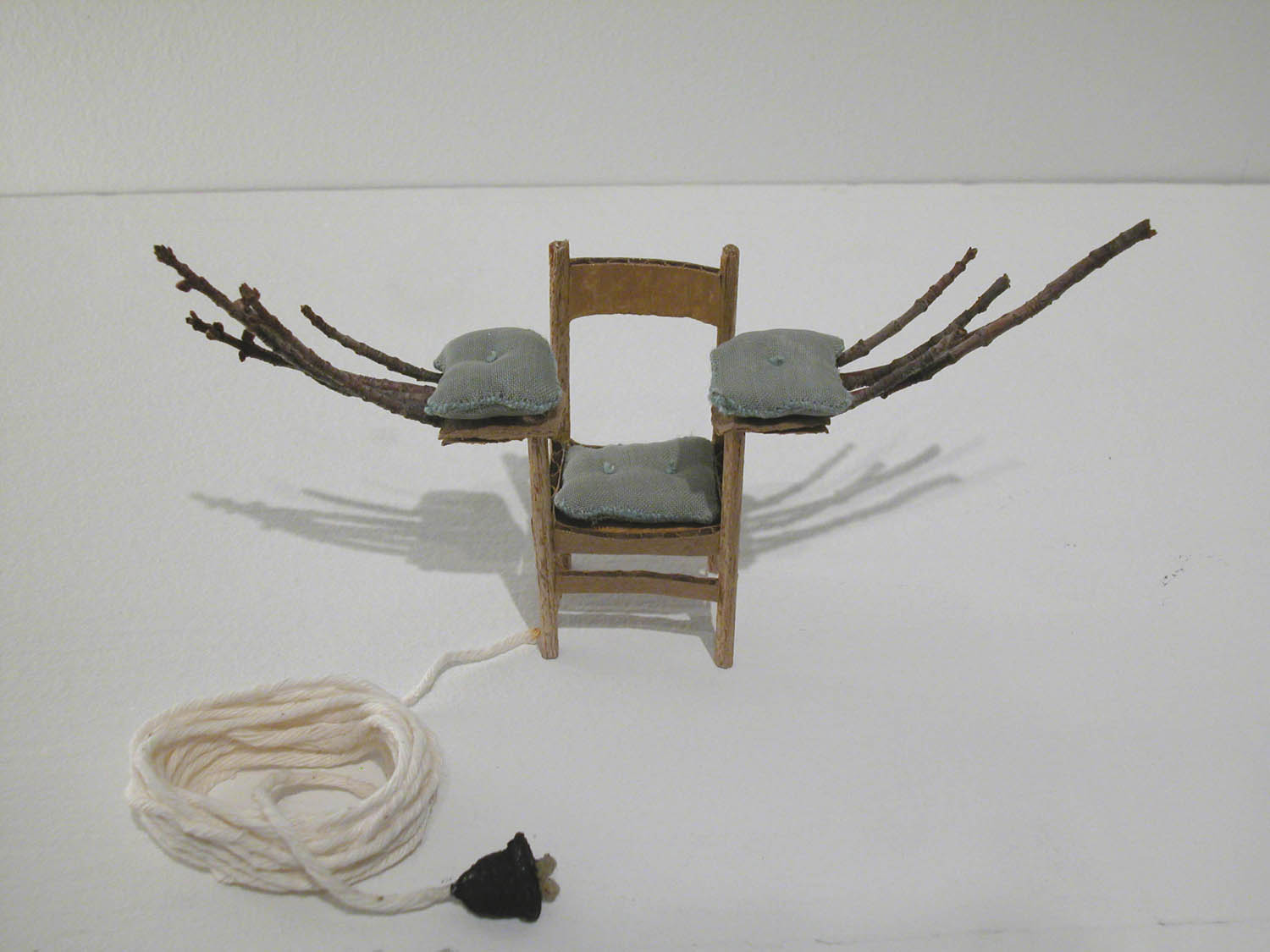 Drawing of a Wood Chair with pillows and sticks coming out of the arms