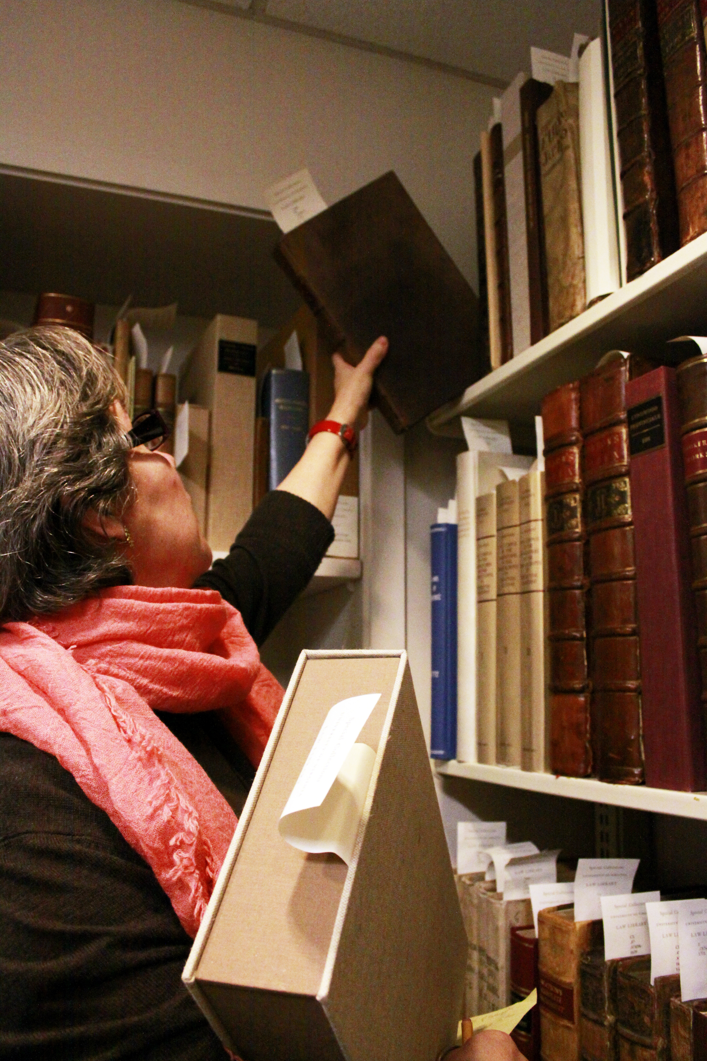 Woman getting old books off the shlef