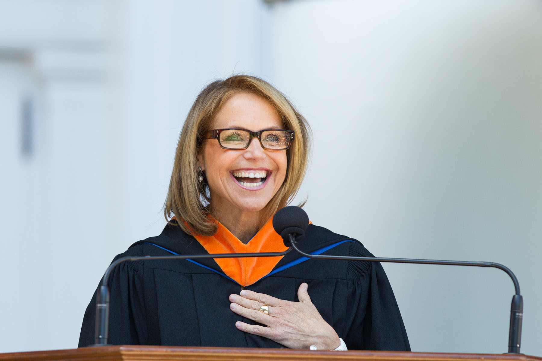 Katie Couric speaking from a podium at graduation