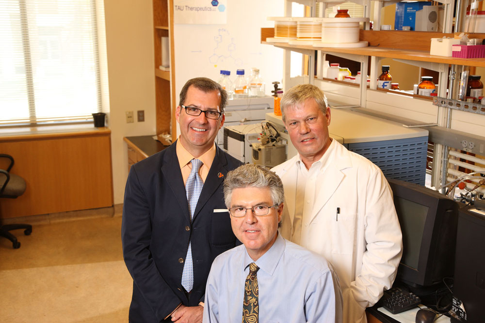 Andrew Krouse, Timothy Macdonald (center) and Lloyd Gray stand together in a lab smiling at the camera