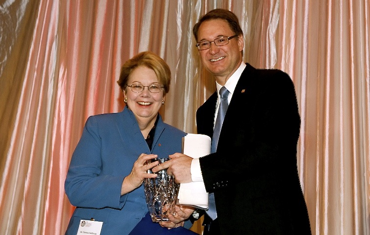 President Teresa A. Sullivan stands with George Schindler smiling at the camera