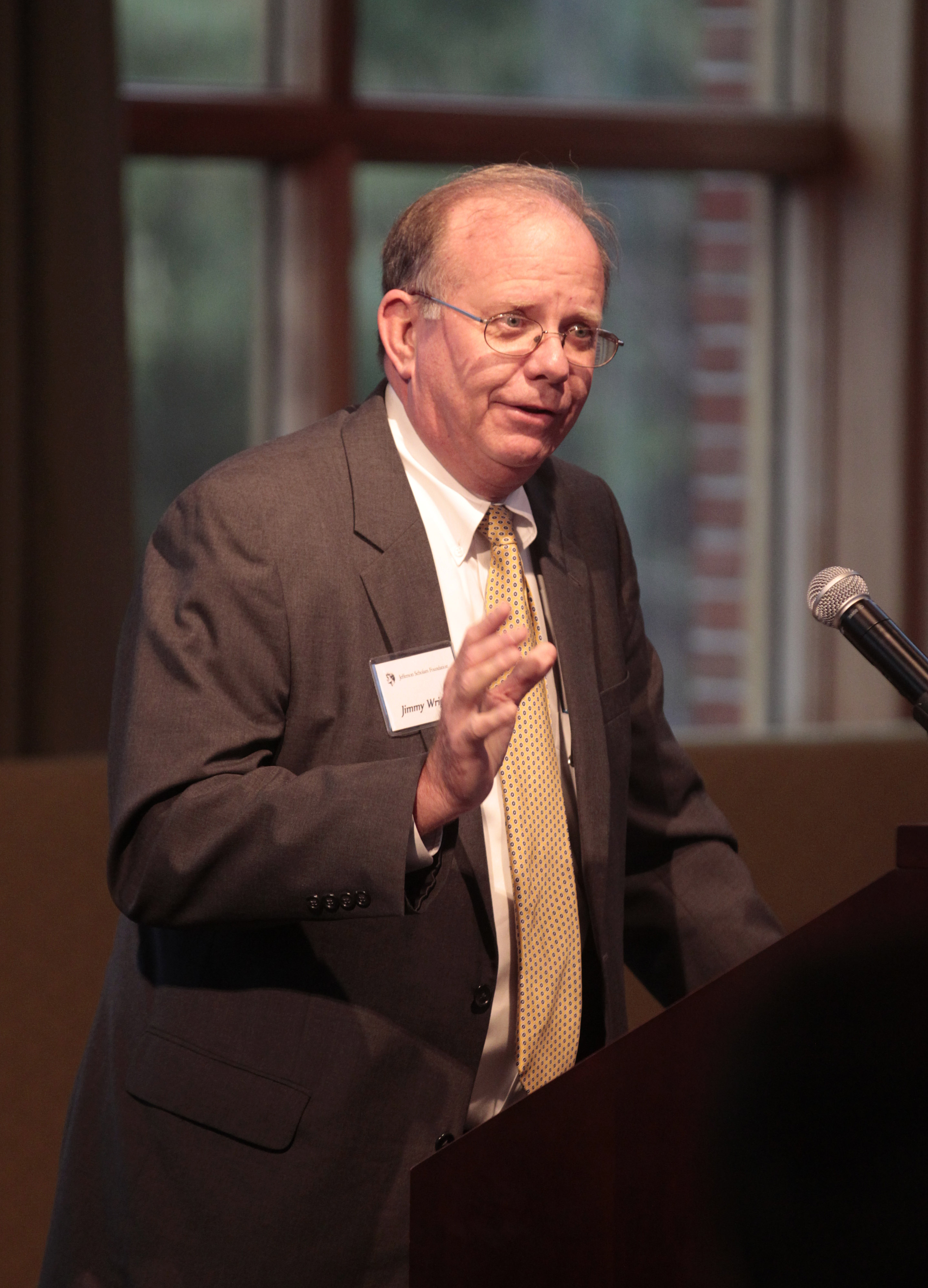 Jimmy Wright speaking at a podium to a crowd