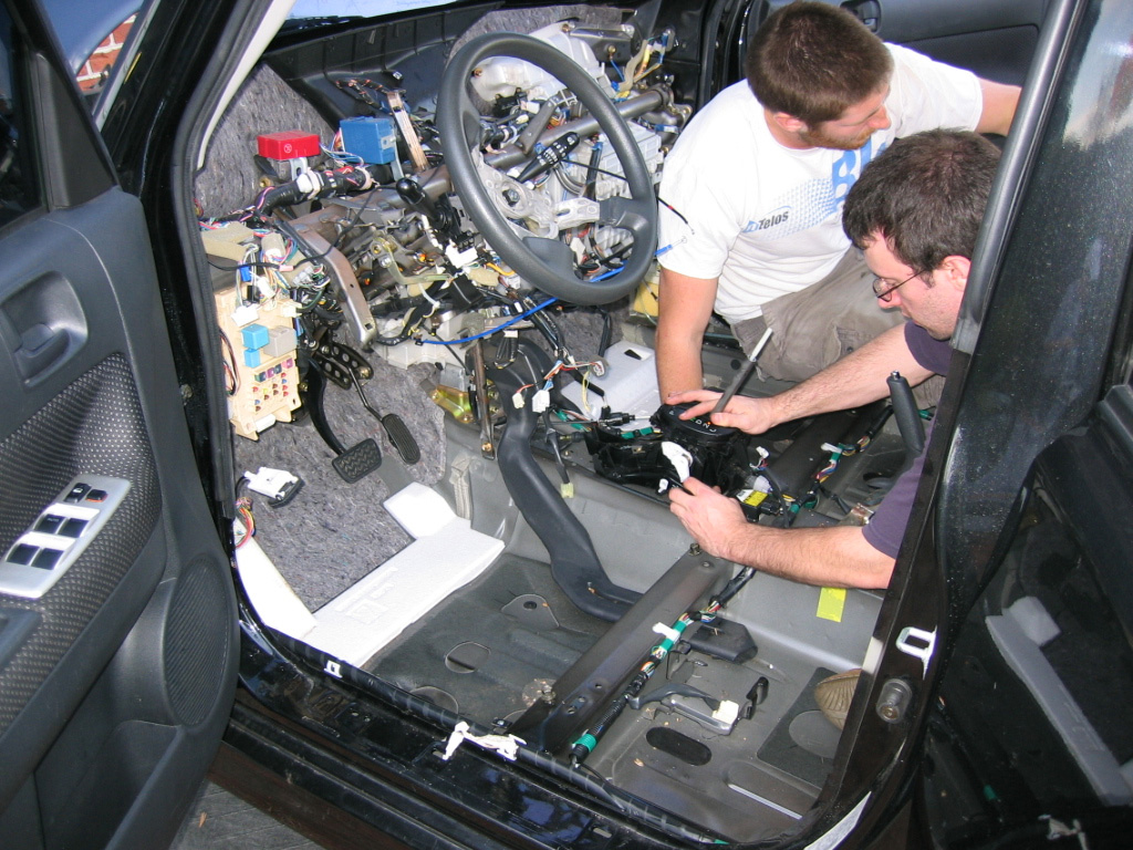 Mike M. Myers and Micheal J. Forkin working on a car