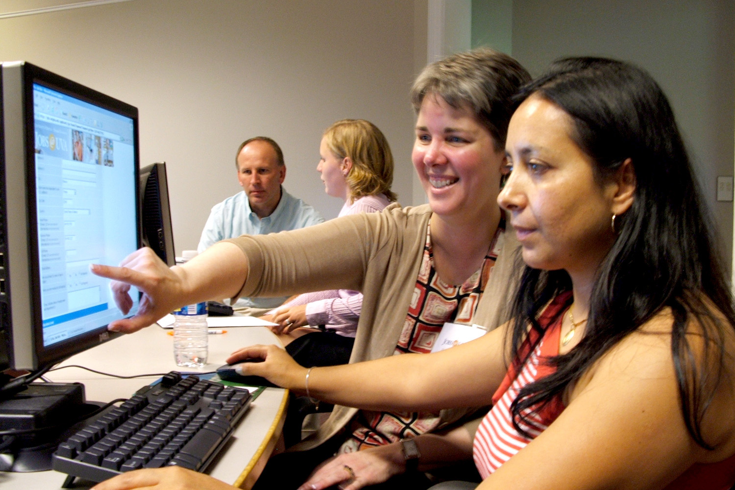Donna Kauffman (left) and Rosario 'Ninel' Espinosa Foss, right, work on a computer together