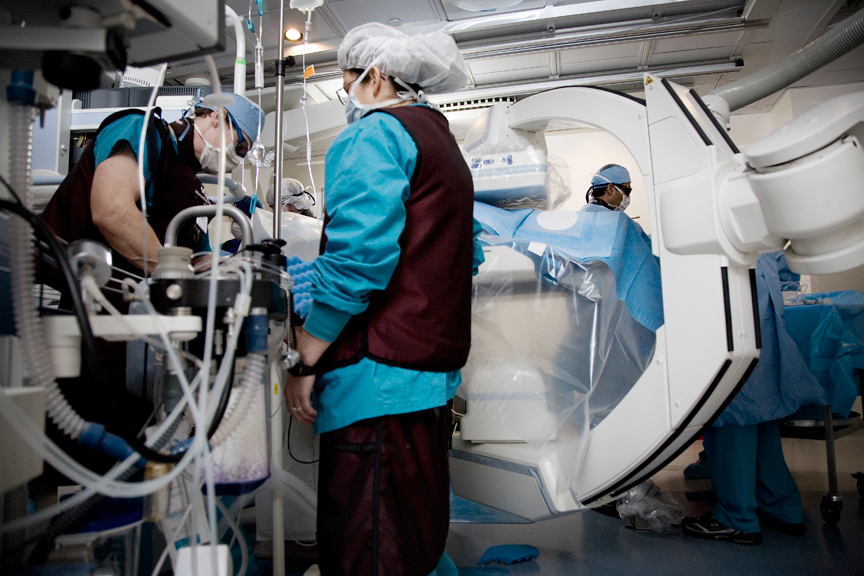 Robotic C-shaped arm in an operating room with a medical team working