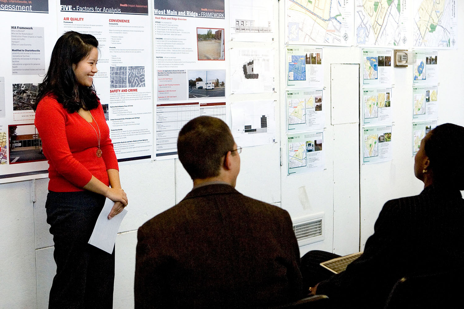 Student talks to a group of people about her poster presentation