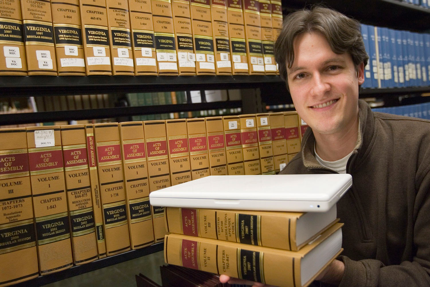 Waldo Jaquith holds to law books and a laptop