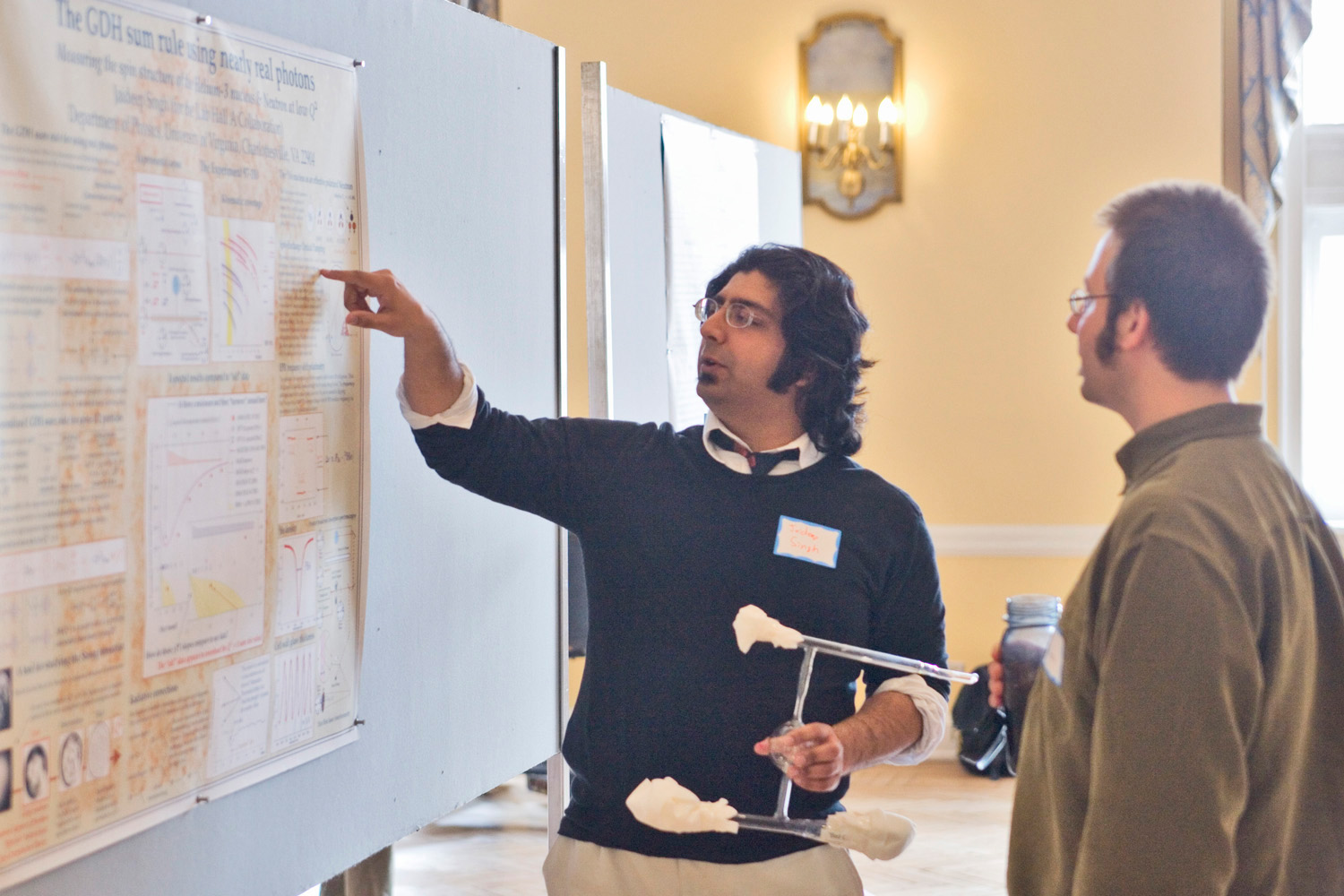 Robert J. Huskey talks to a man about his poster presentation