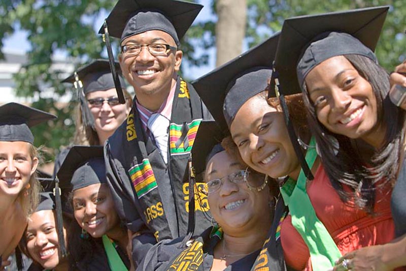Students in Graduation attire pose together for a group photo
