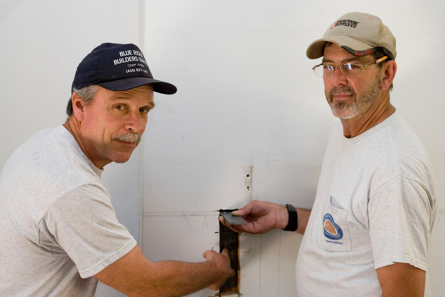 Greg Bugg and Linwood Marshall work together to repair a wall