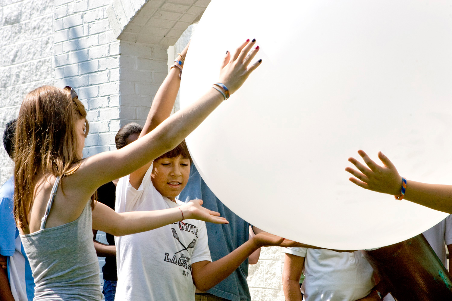 Children holding a big white weather balloon
