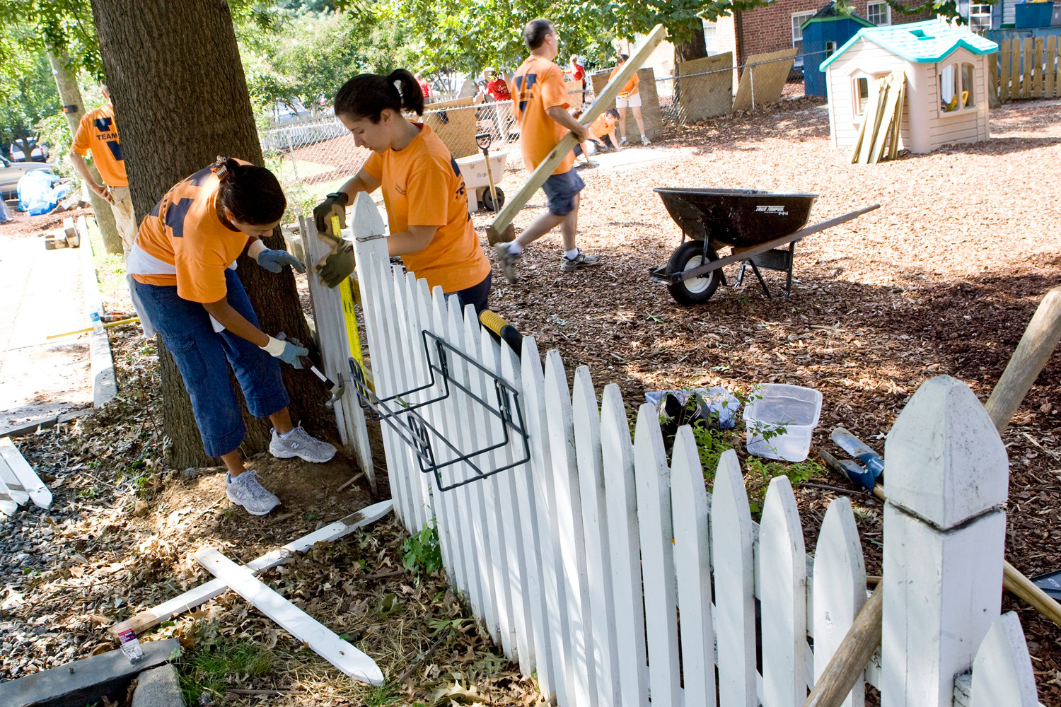 UVA Employees repairing a white picket fence