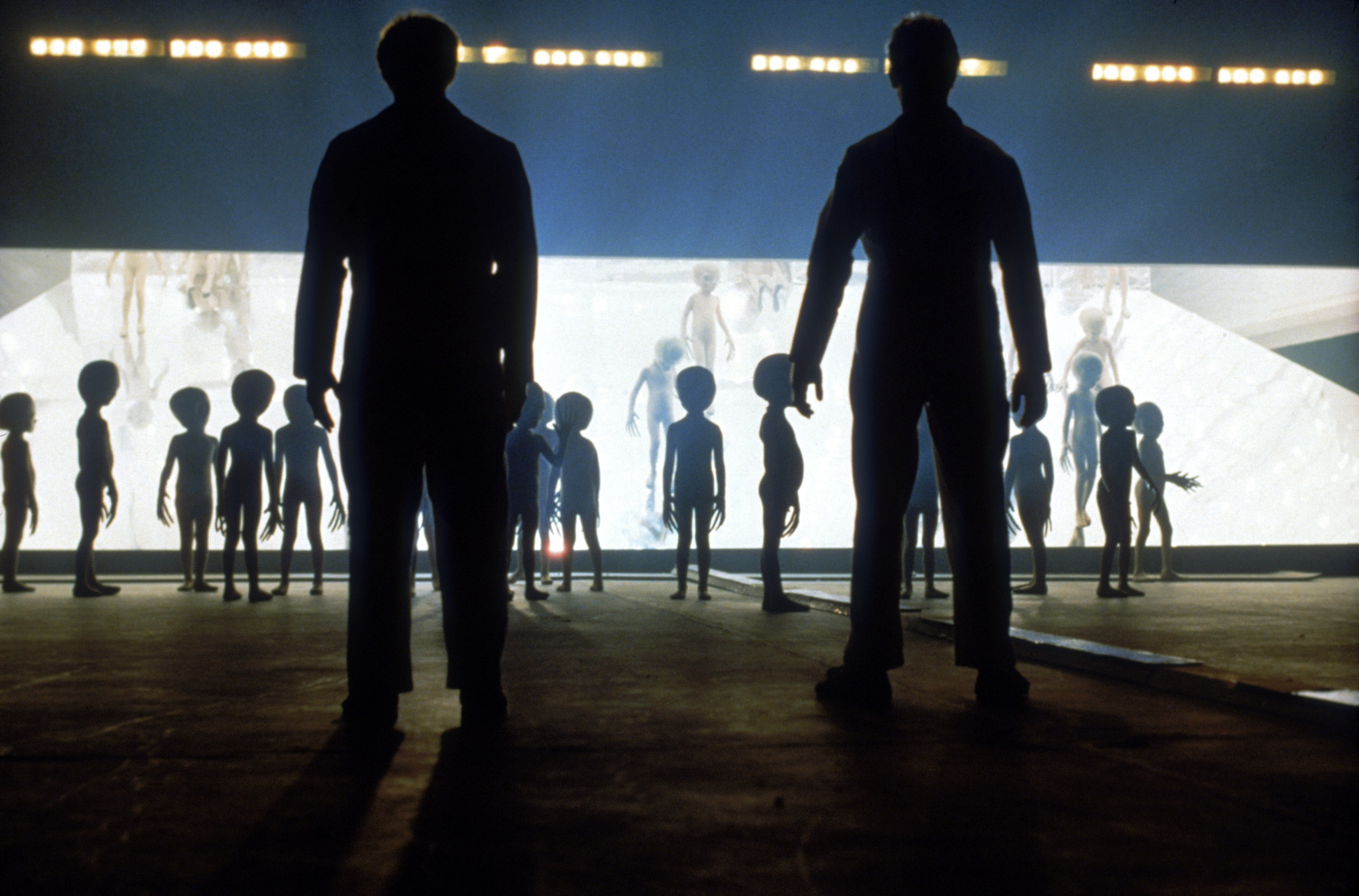 Aliens facing two humans on the set of Close encounters of the third kind