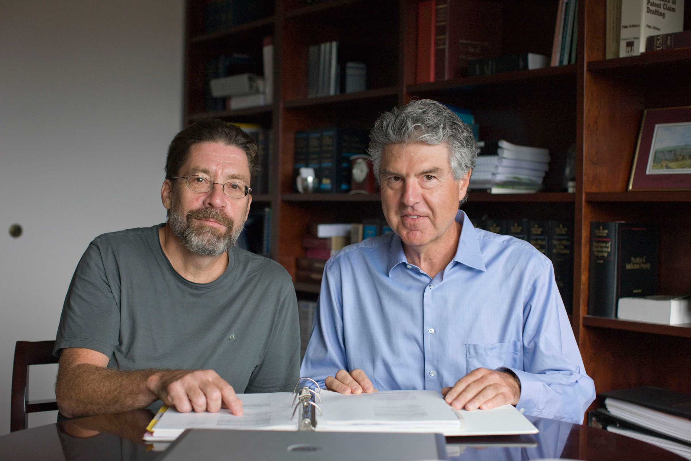 Kevin R. Lynch and Timothy L. Macdonald sit at a table smiling at the camera