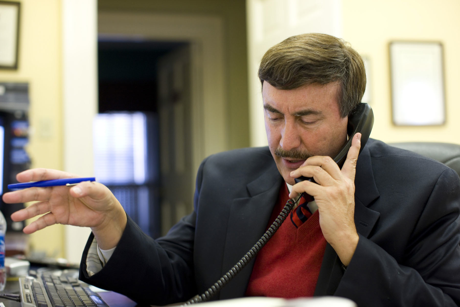 Larry Sabato talking on the phone at a table