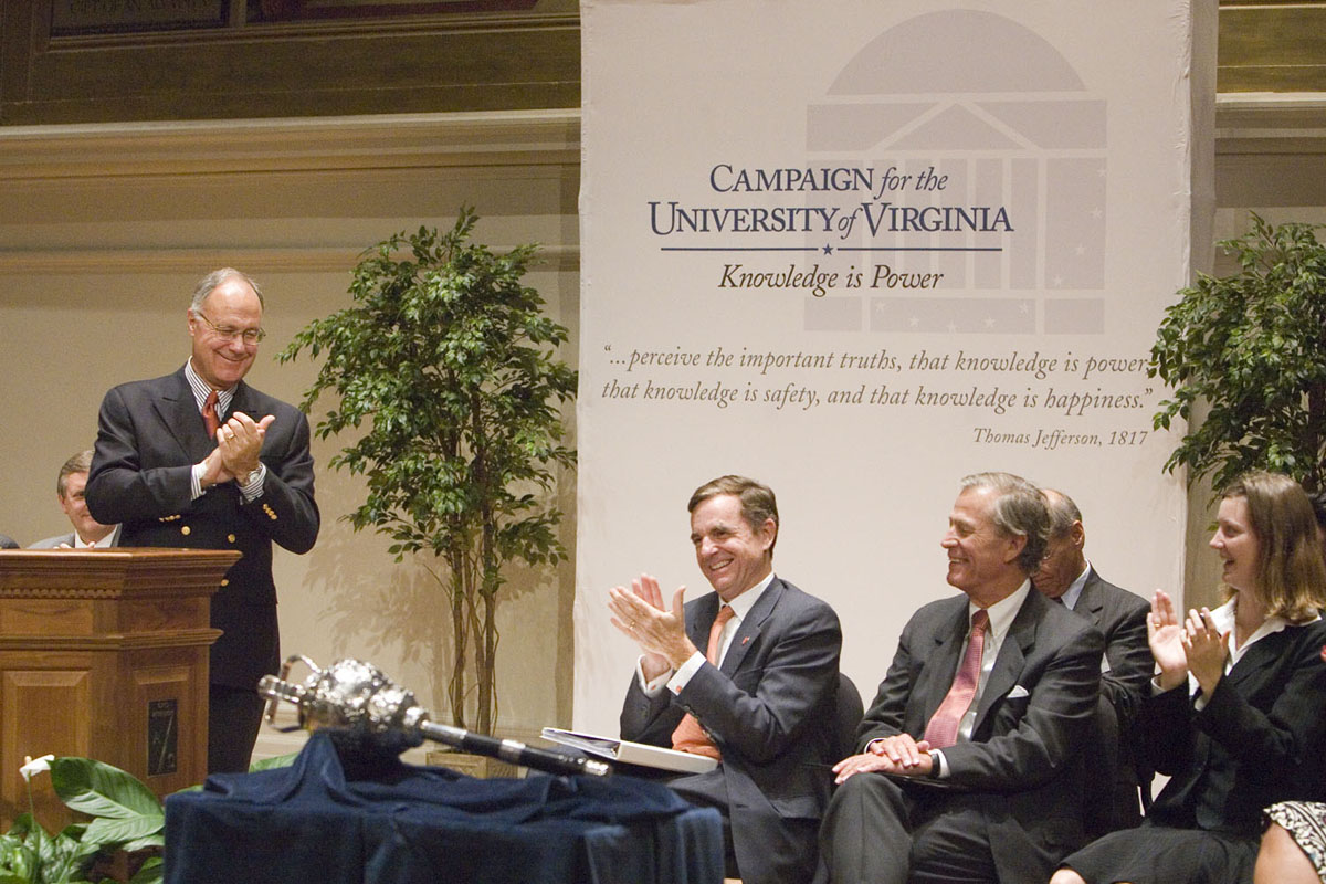 President John T. Casteen III recognizes Gordon Rainey (right) while Rector Thomas Farrell (center) applauds.