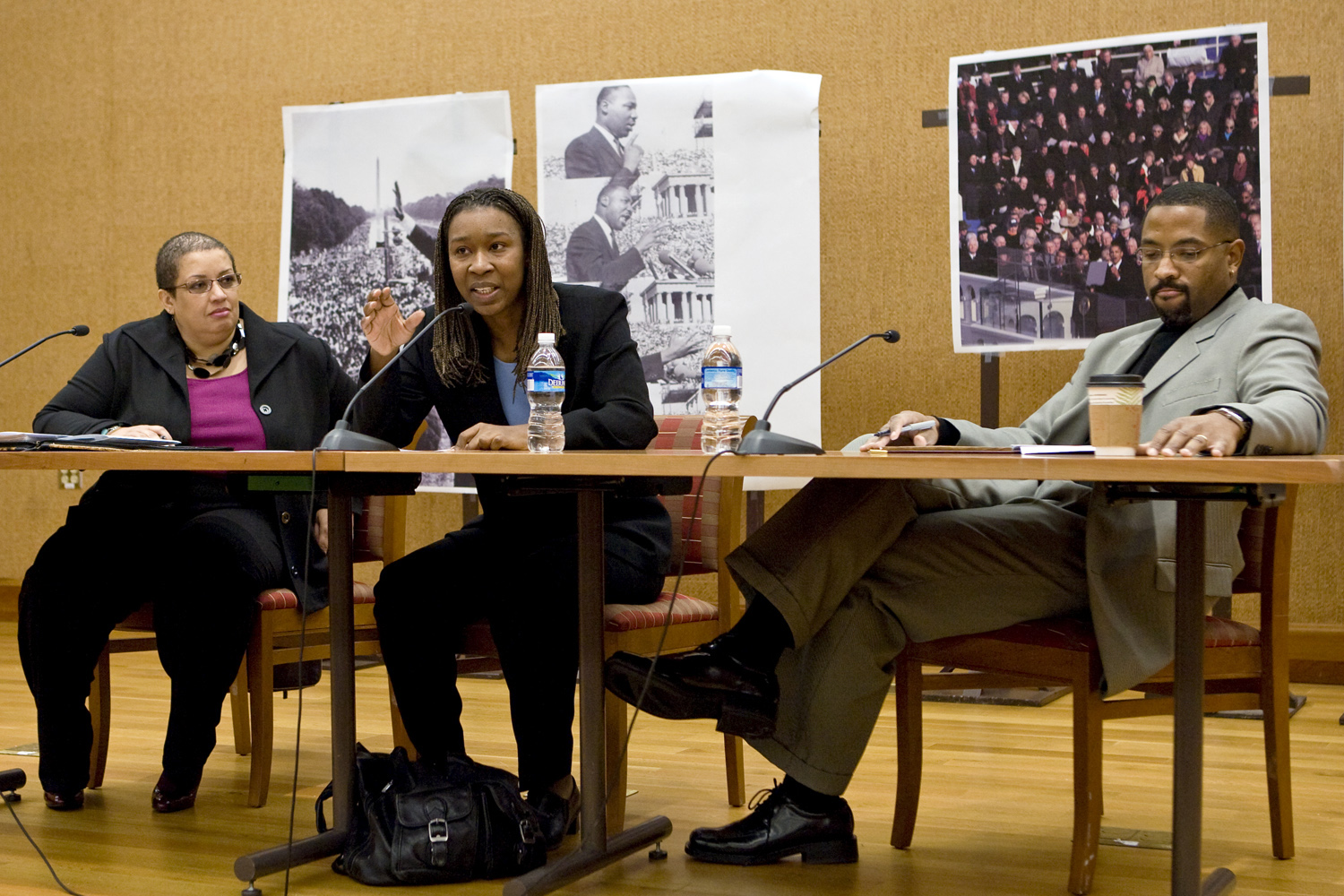 Panelists sit at a table talking into microphones at a MLK discussion