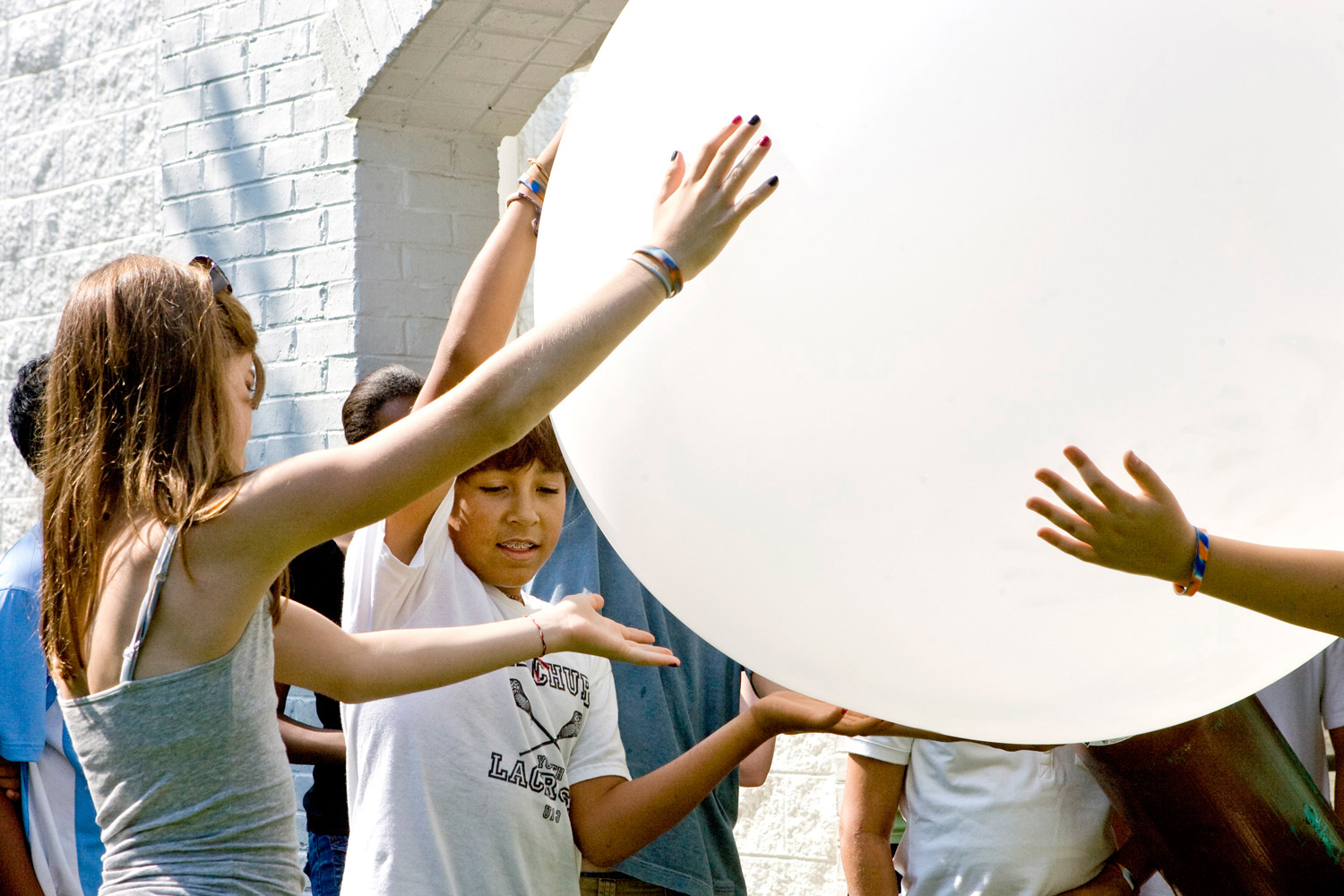 Students holding a huge white weather balloon