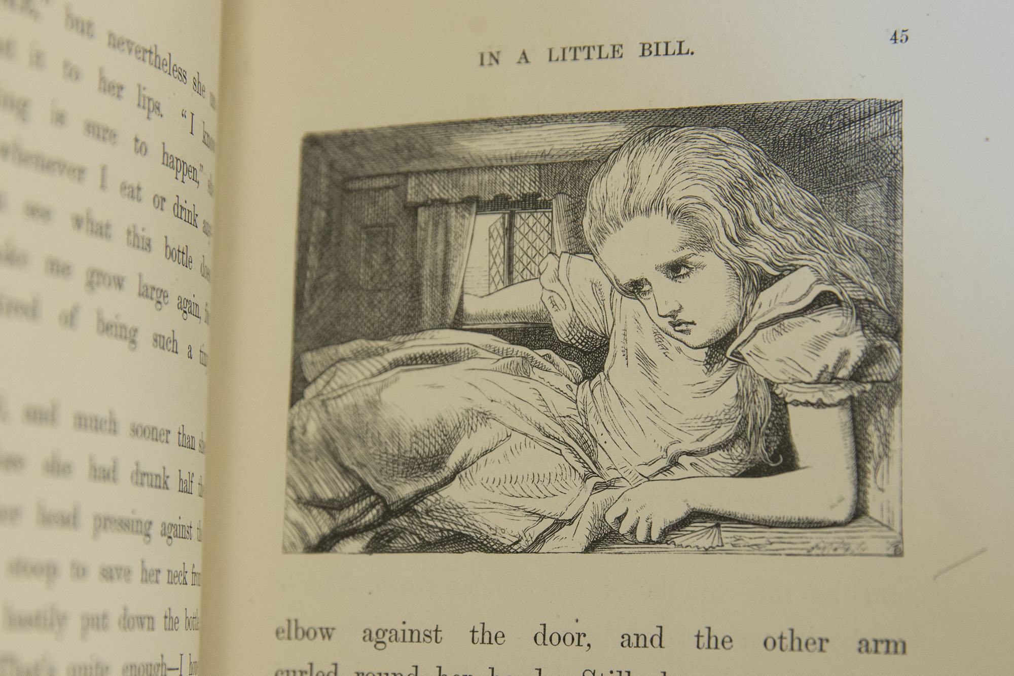 Black and white picture in a book of a little girl scrunched up in a little room