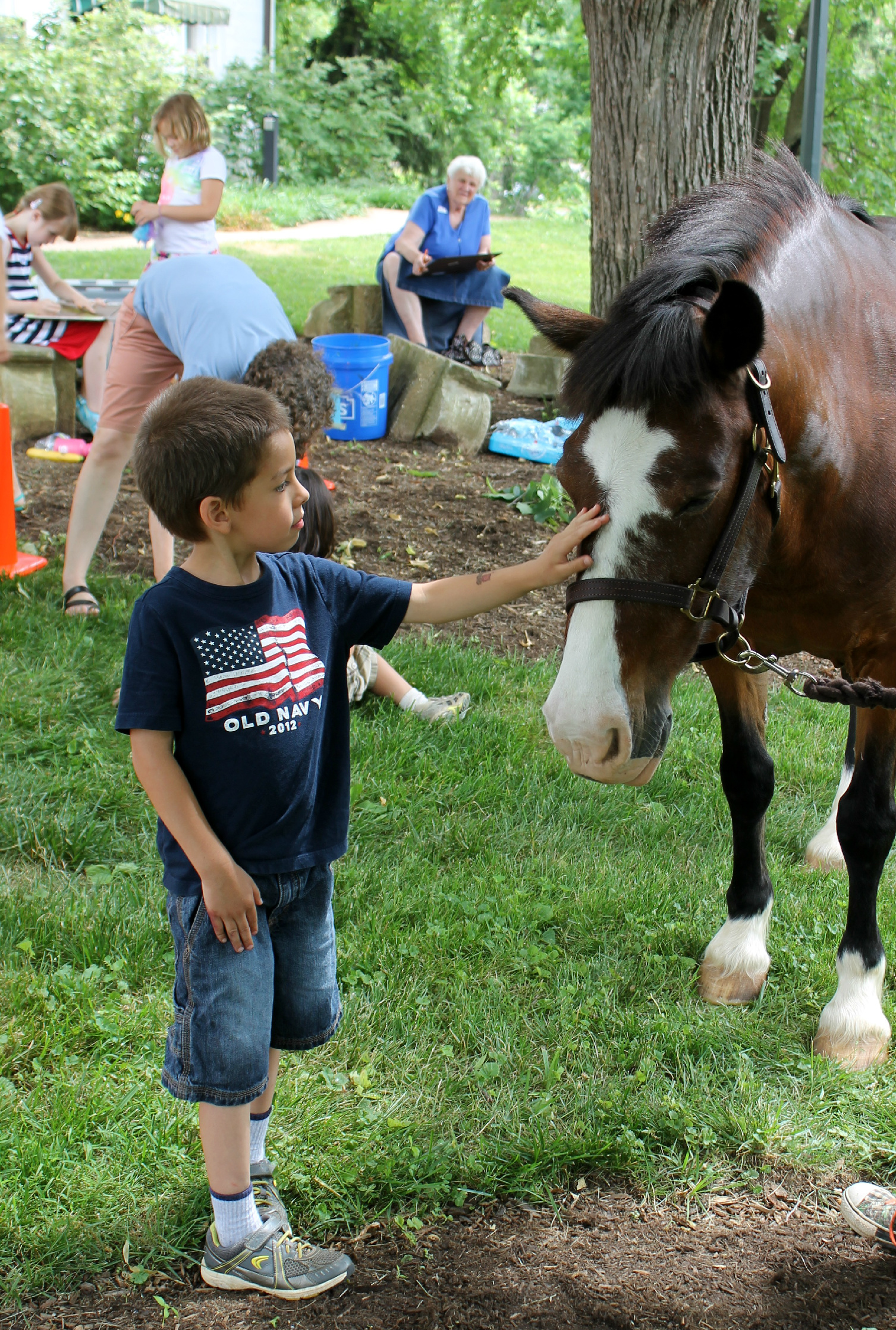 Little kid petting a horses face