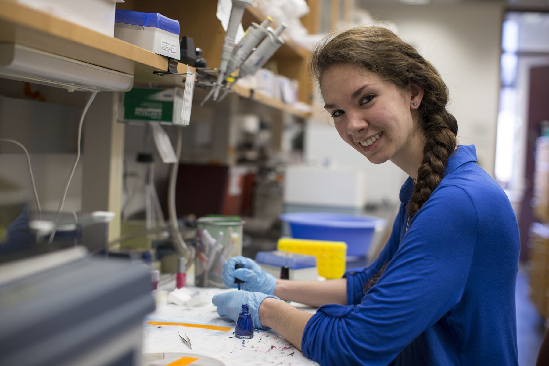 Catherine Hentry working in a lab smiling at the camera
