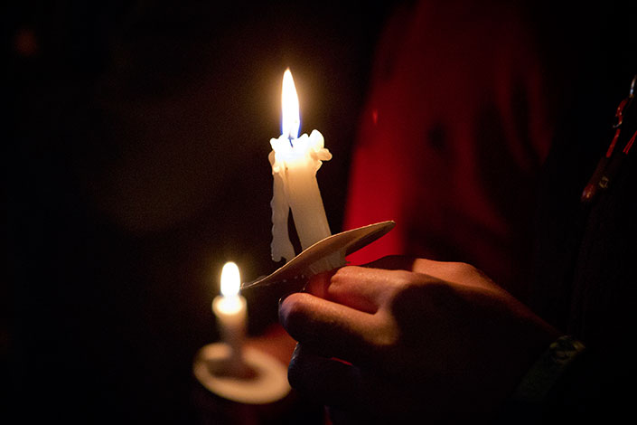 Person holding a lit candle