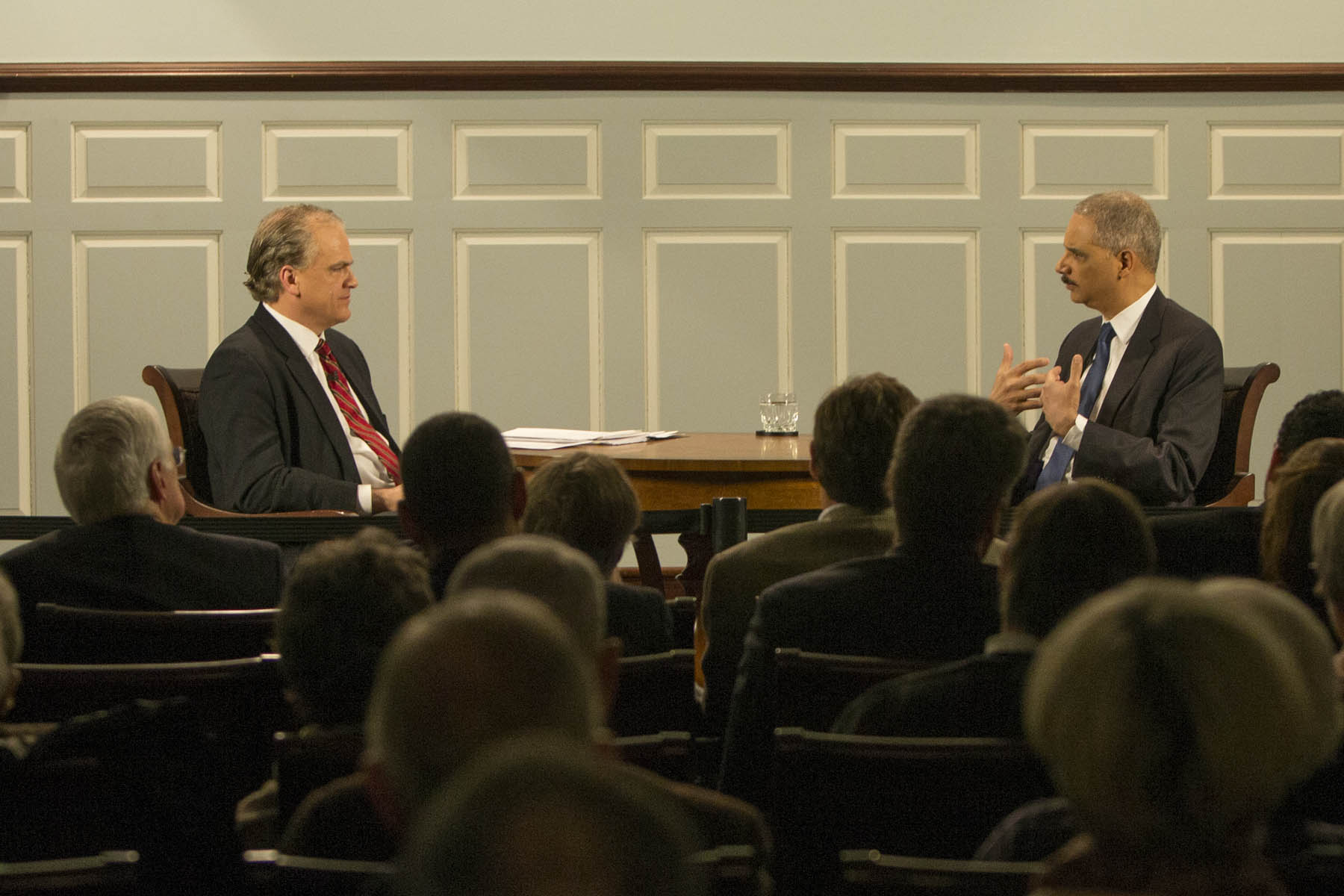Douglas Blackmon (left) interviewing Attorney General Eric Holder (right) in front of a crowd