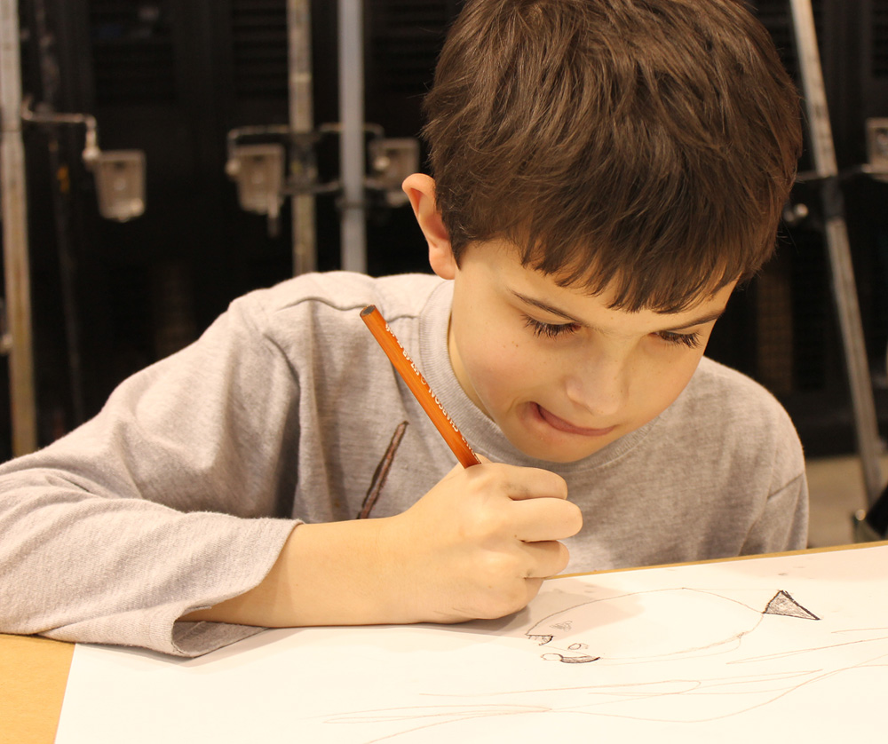 Little boy drawing on a piece of paper