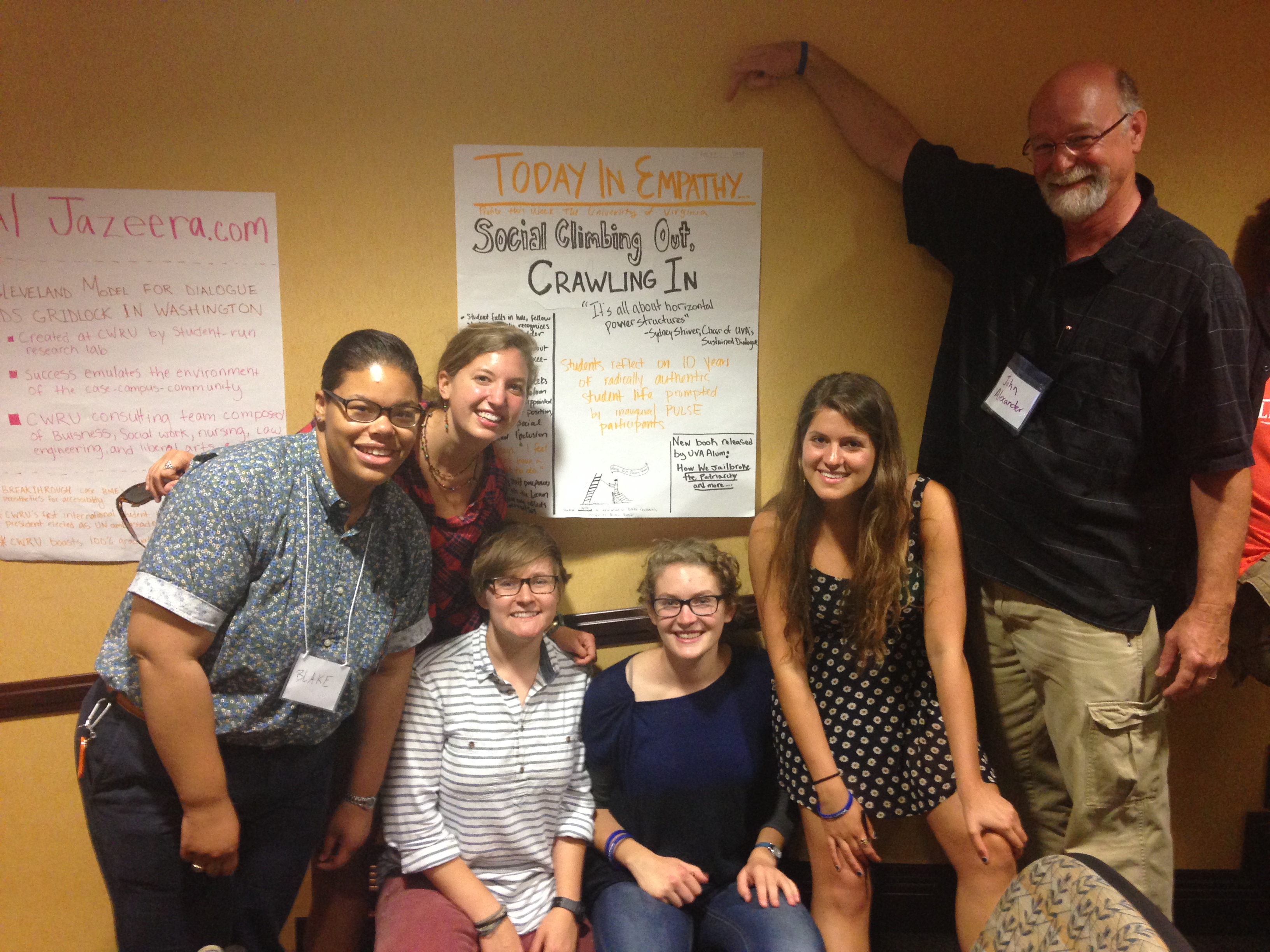 Group photo in front of a poster that reads: Today in Empathy Social climbing out, crawling in
