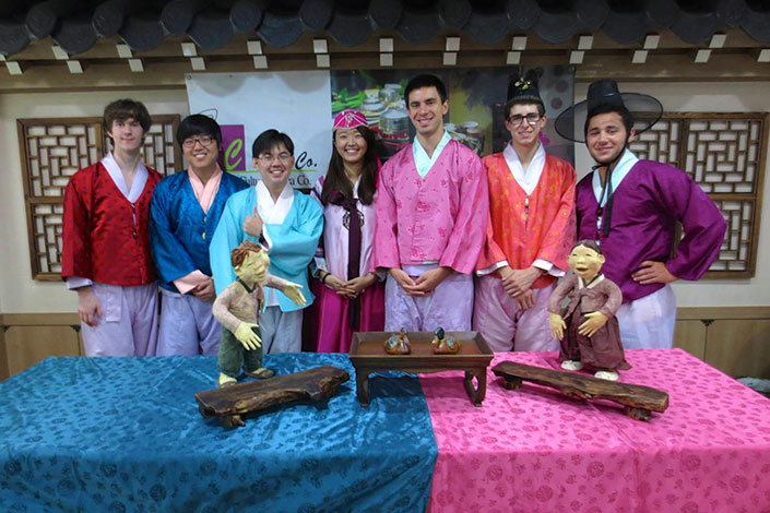 Students wearing traditional Korean dress smile for a group photo