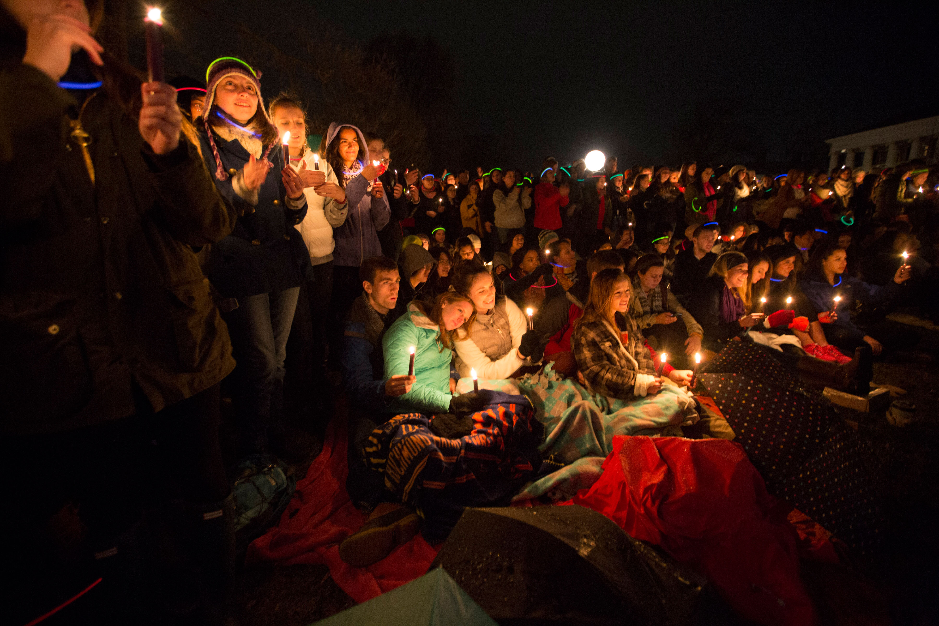 Crowd holding Lights standing close and some sitting on the ground with blankets