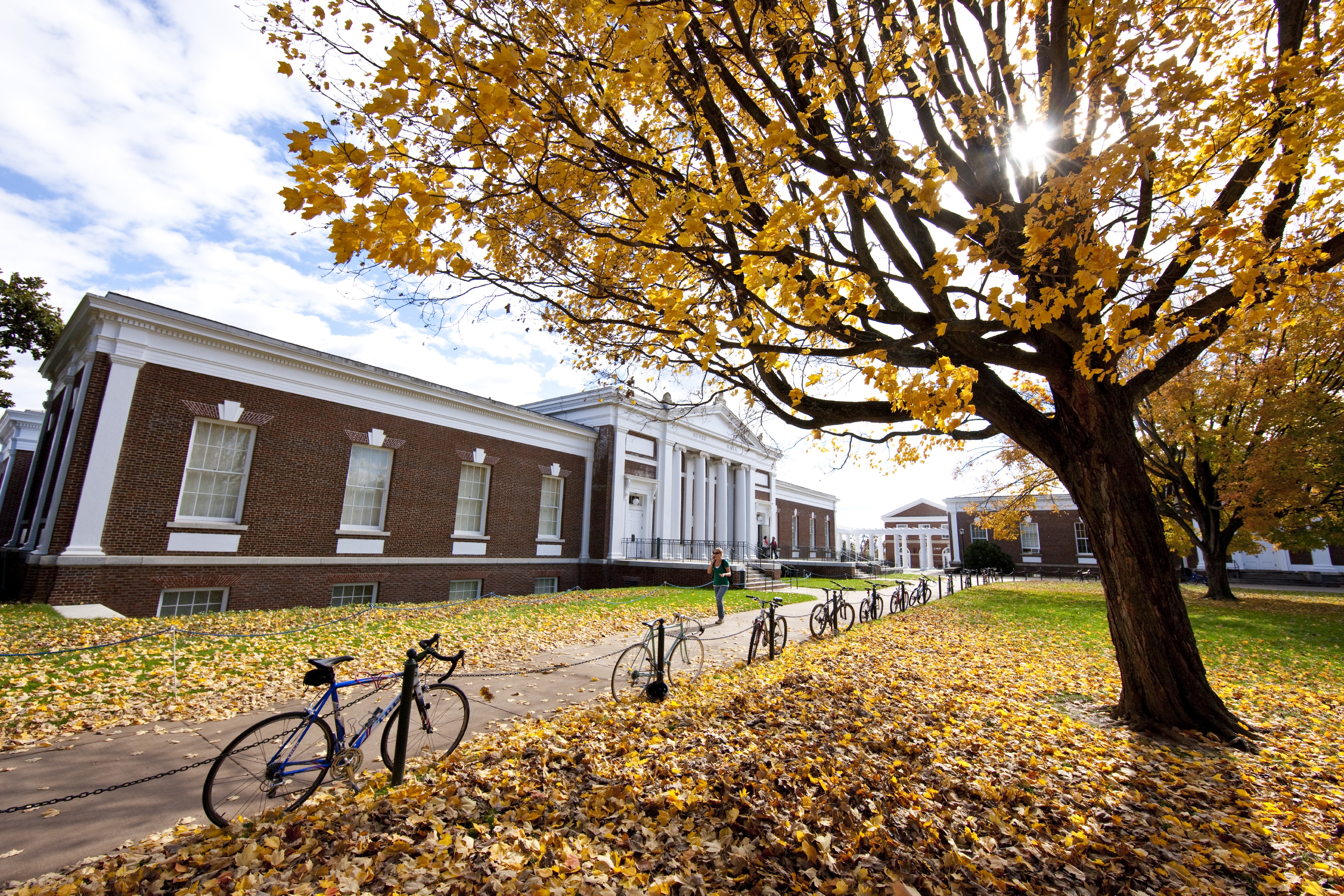 Rouss Hall with bicycles lined up along the chain link fence that is outside of it