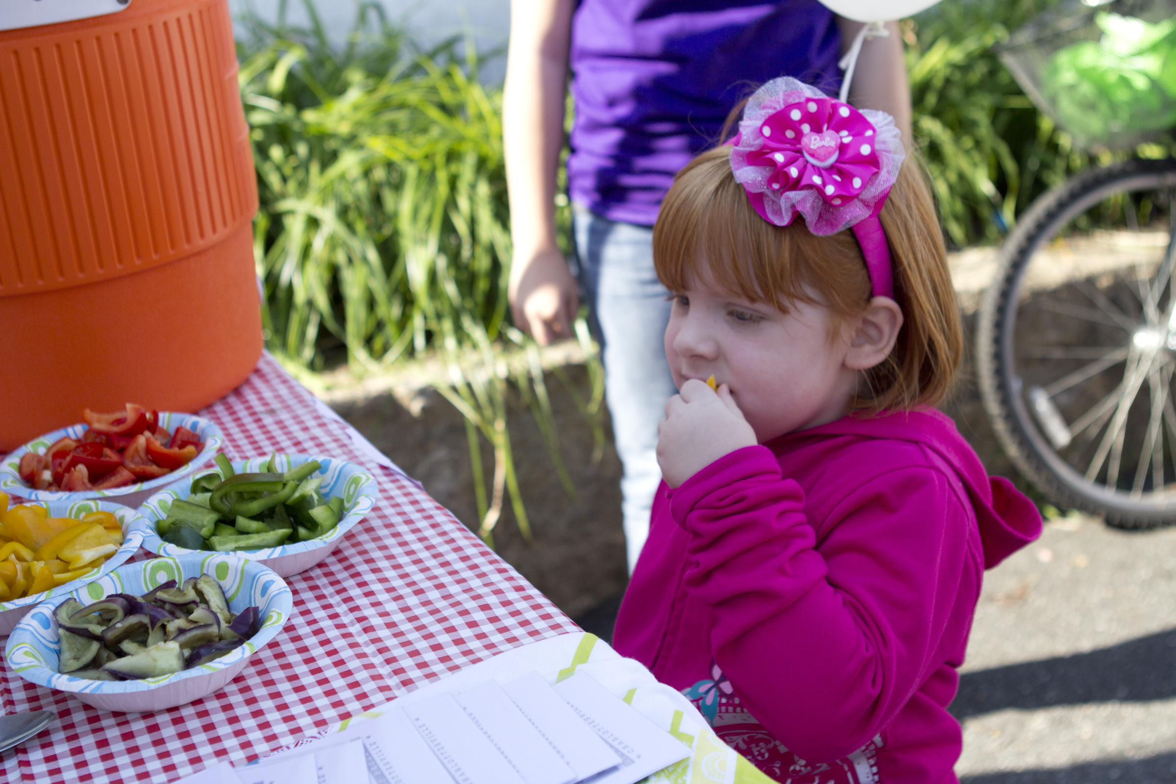 Child eating veggies at a picnic table