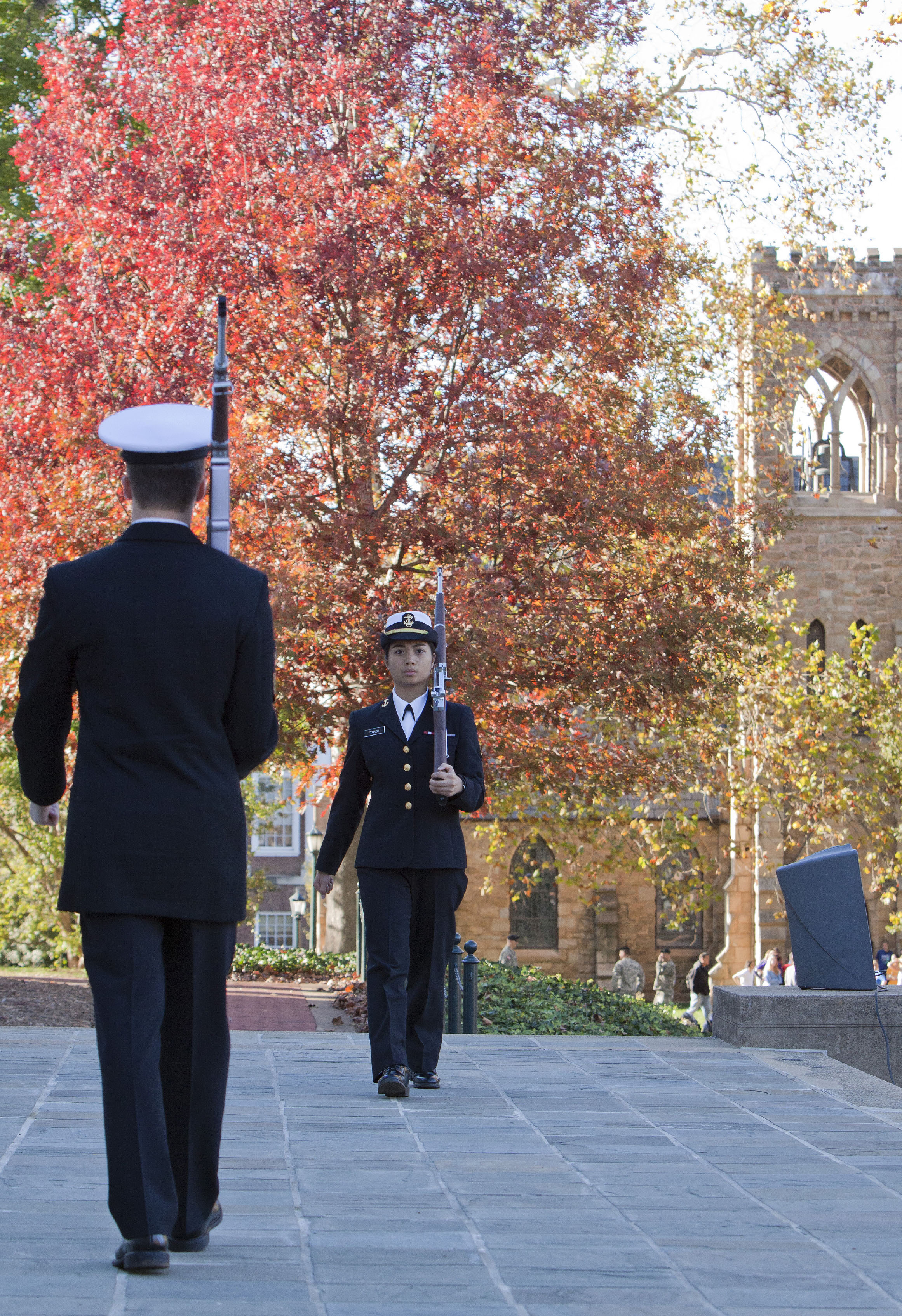 Navy ROTC cadets marching in dress uniforms with rifles