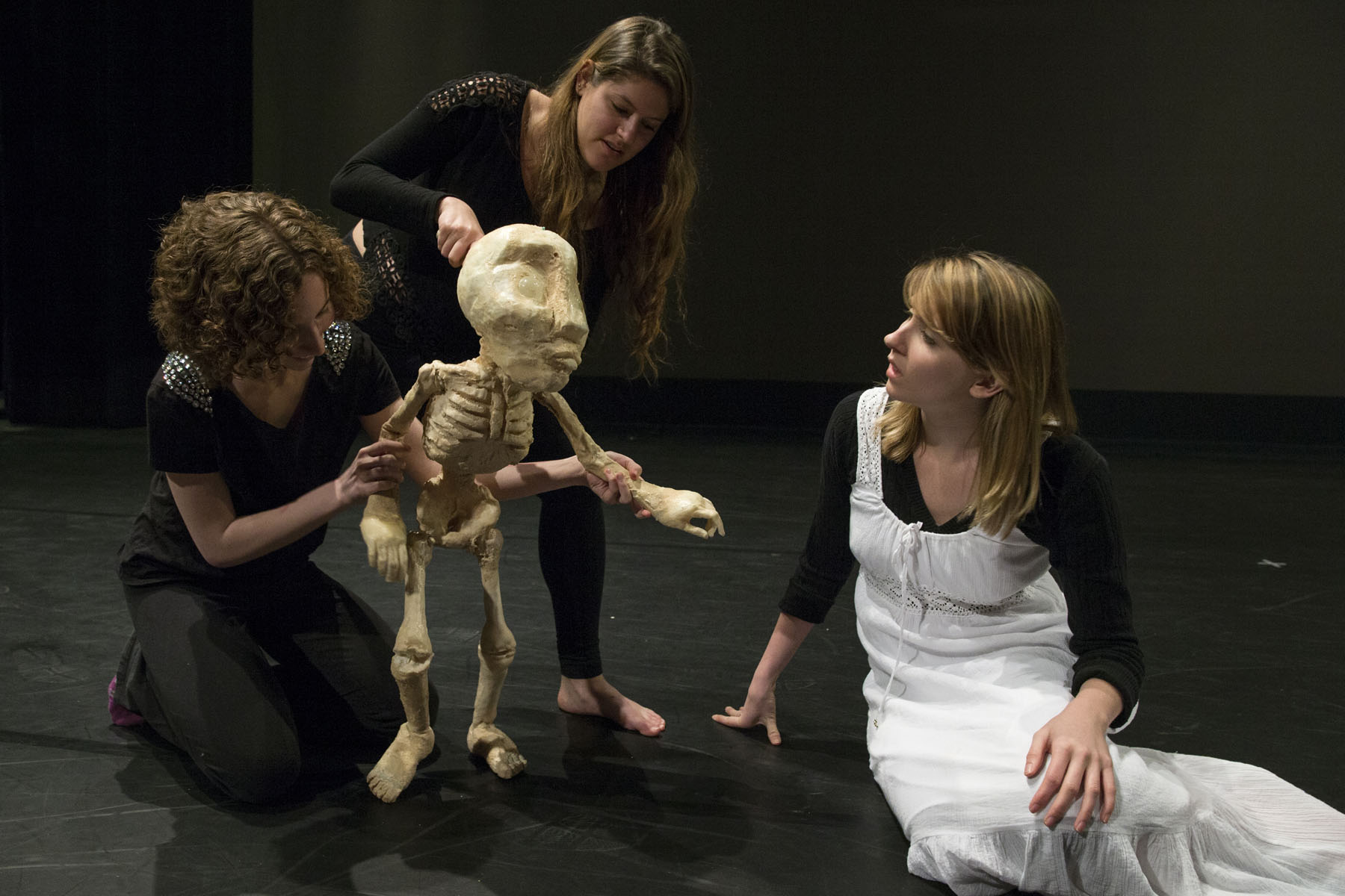 Three actors working on an alien skeleton