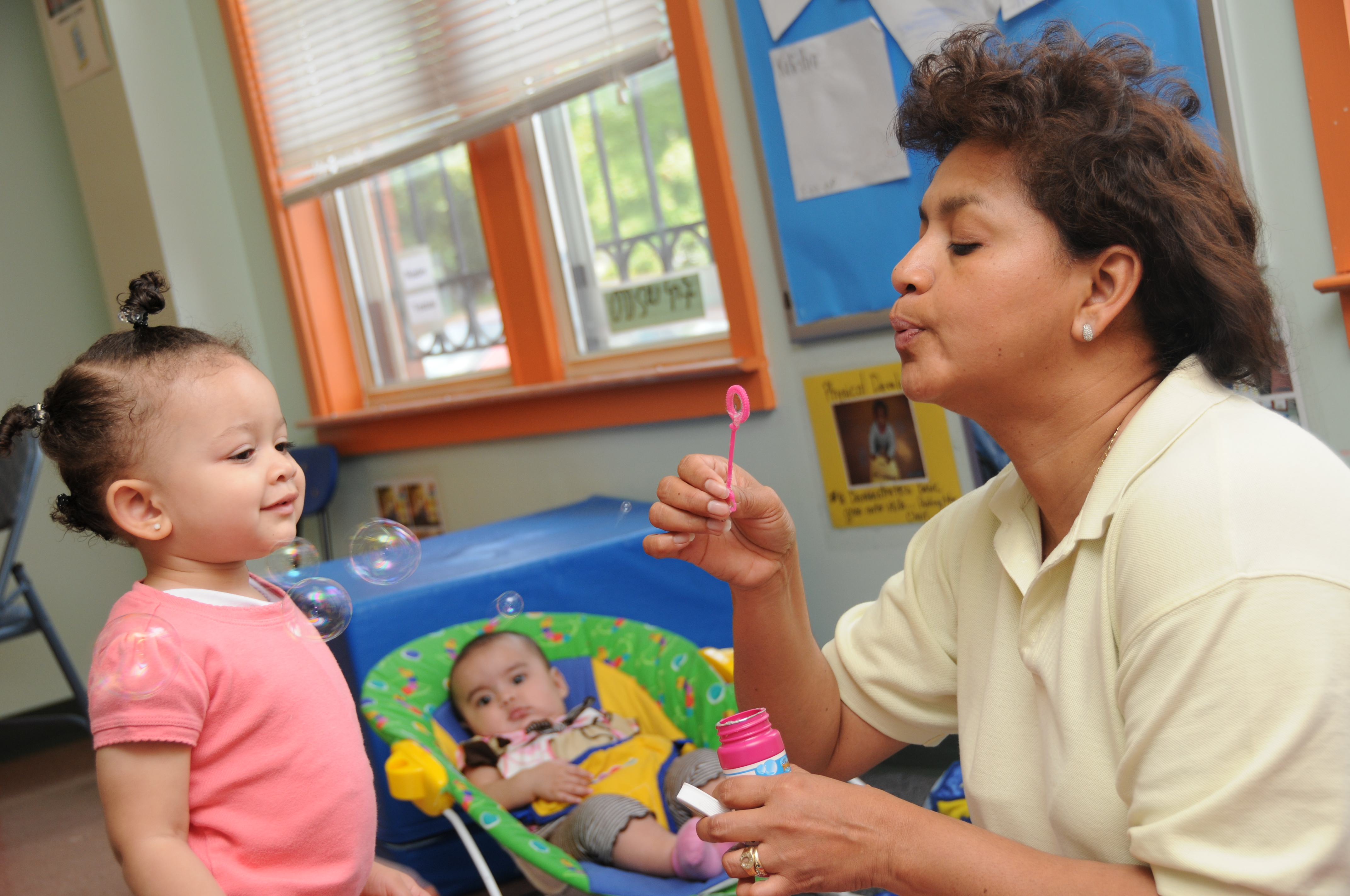 Woman blowing bubbles for a child