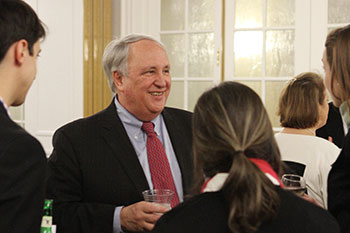 Alan R. Beckenstein talking to a small group of people at a reception