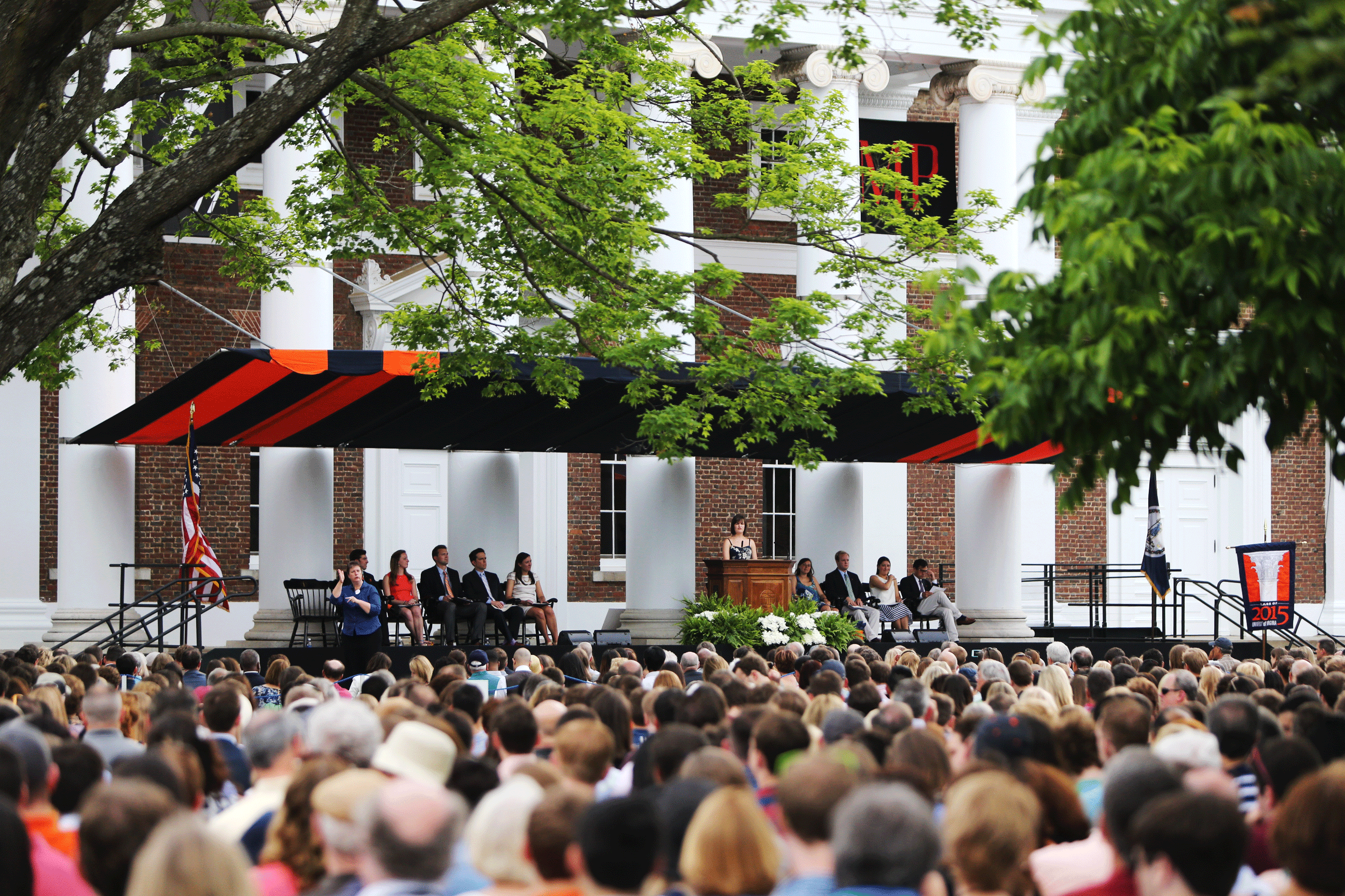 Crowd listening to a speaker on a stage in front of Old Cabell Hall
