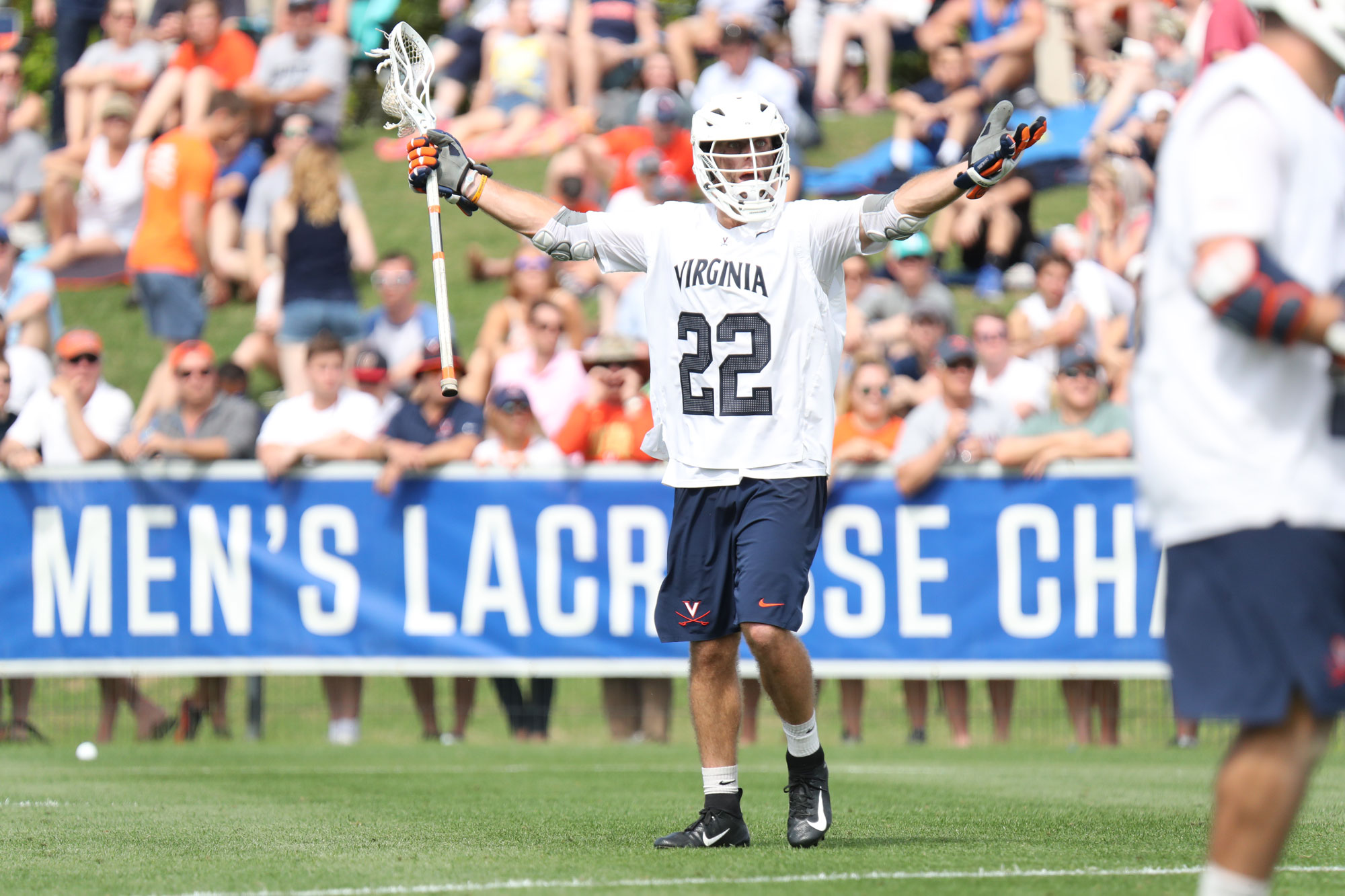 Matt Riley has his hands out wide in UVA lacrosse uniform on field during a game