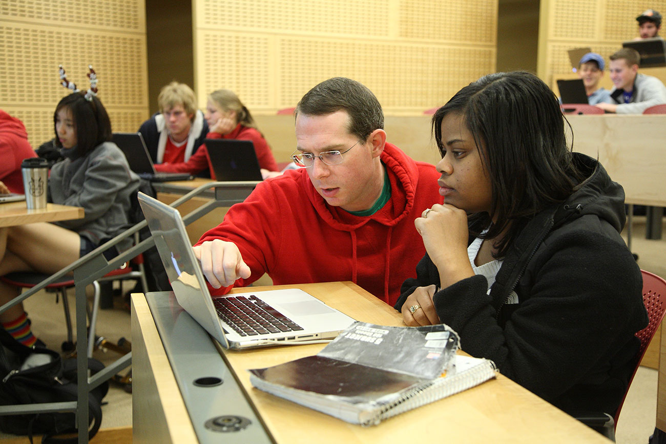 Mark Sherriff helps a student on their computer