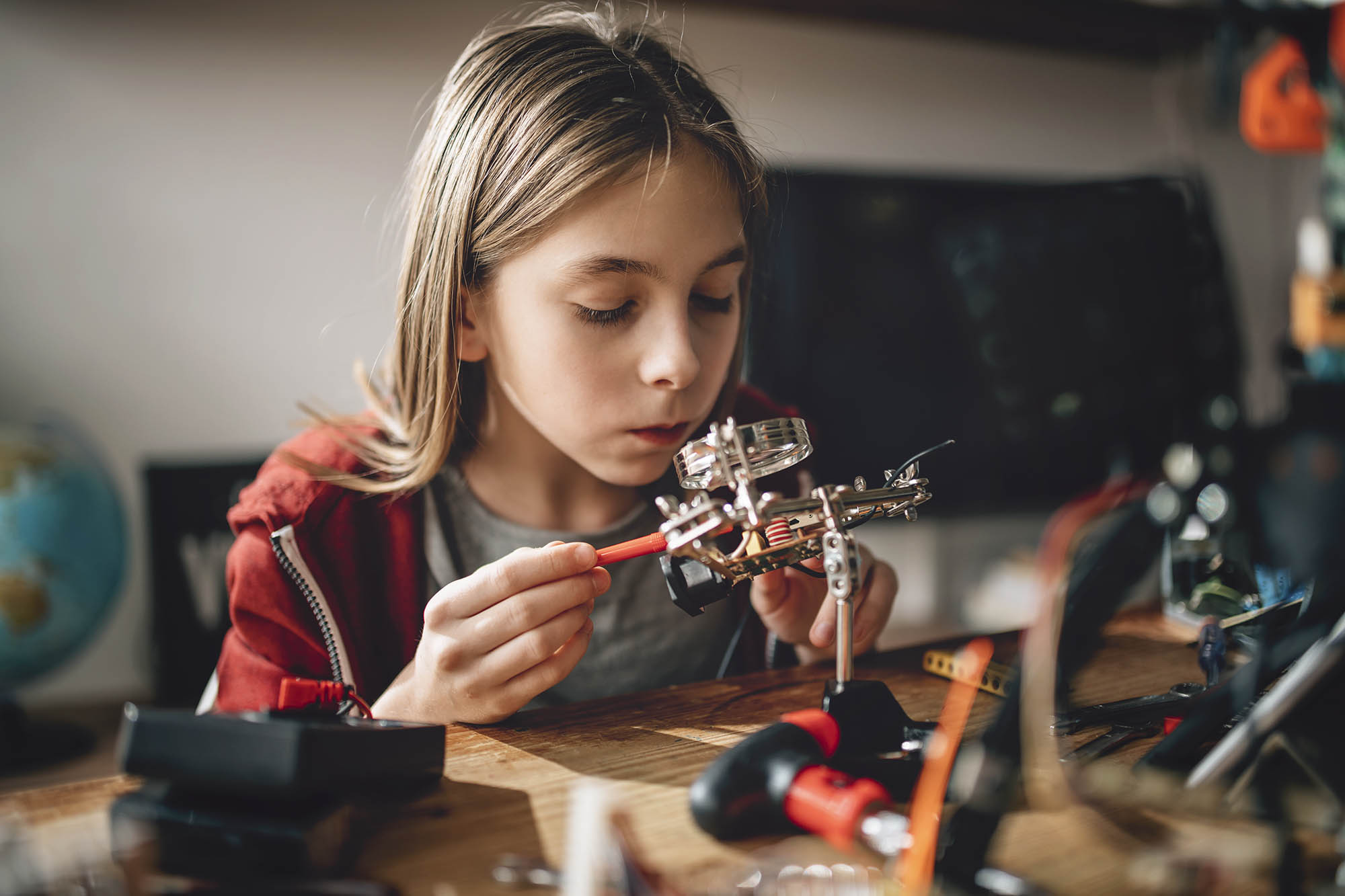 Child using tools to build a mechanical toy